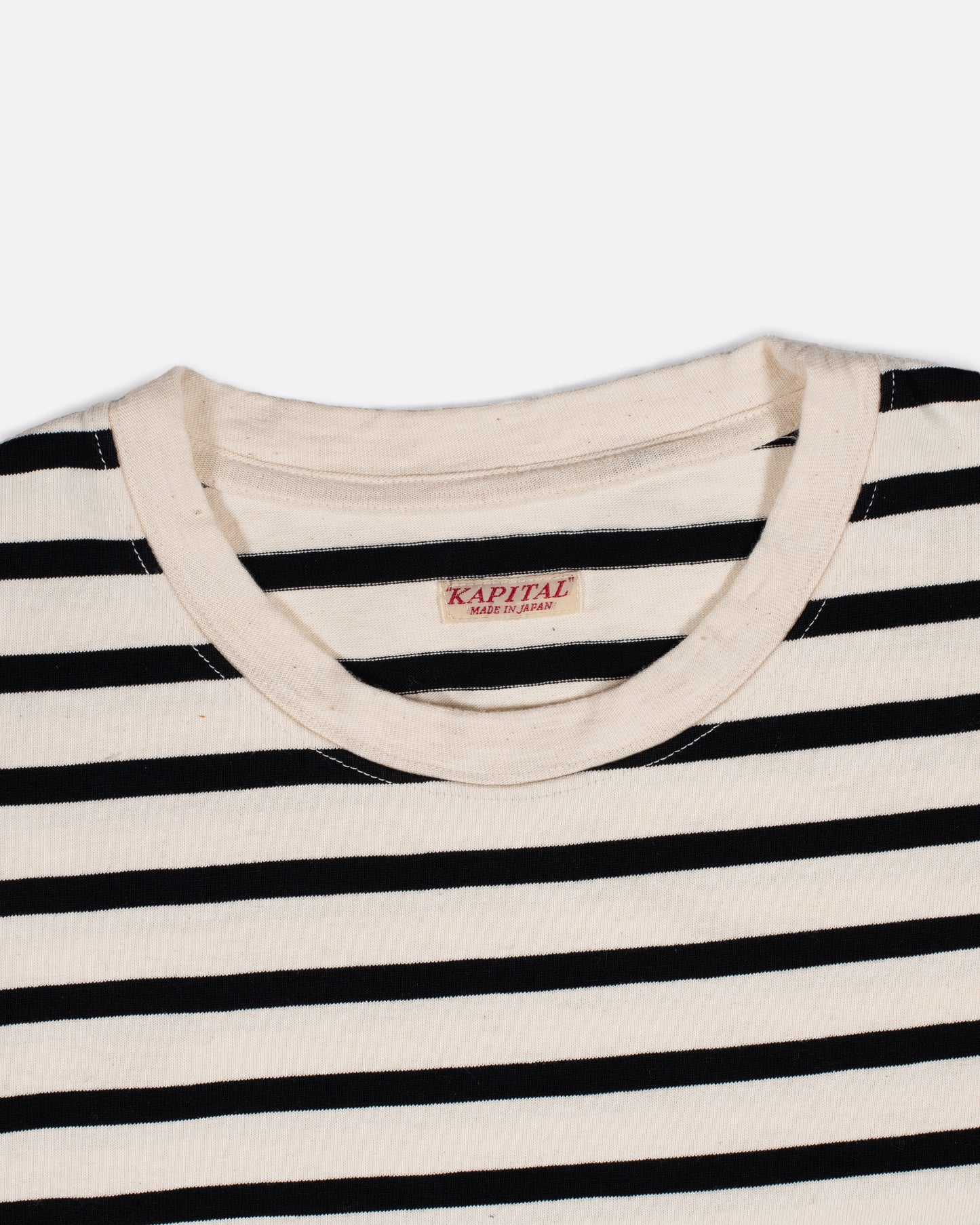 A black and white striped, cotton, crewneck shirt with Kapital's fan favorite rainbow smiley elbow patches.