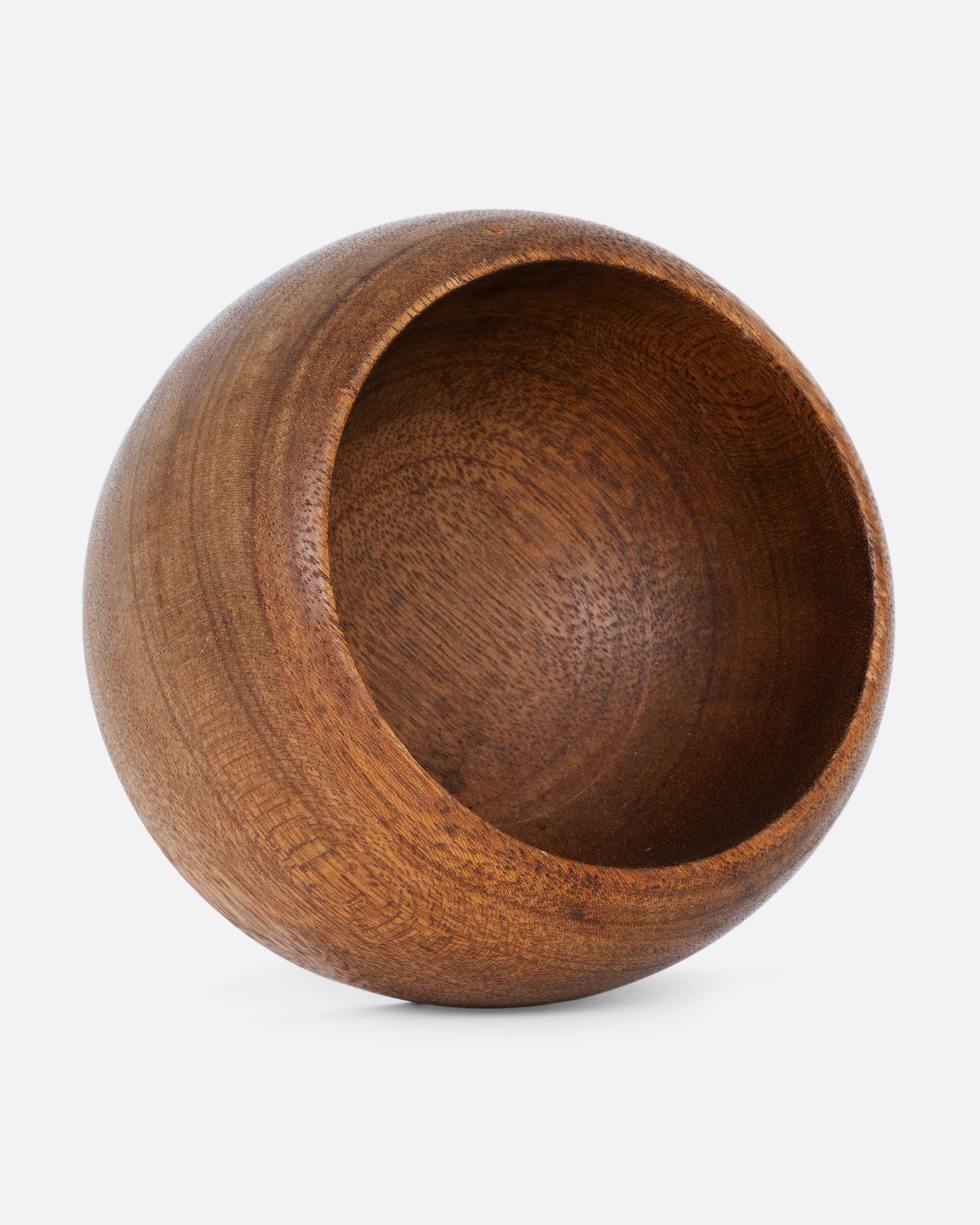 A wooden bowl shown standing up on its side.