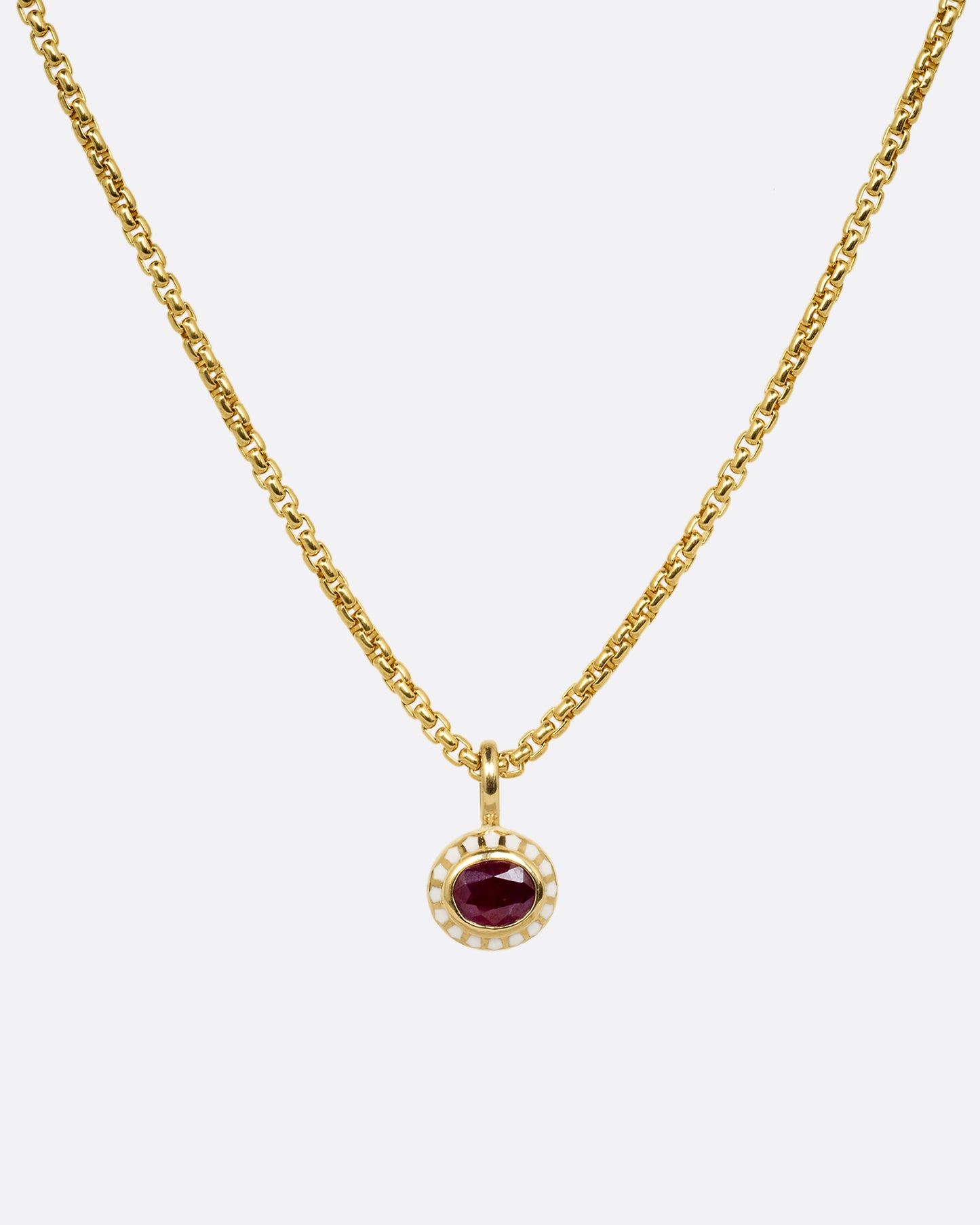 yellow gold ruby pendant with enamel shown from afar
