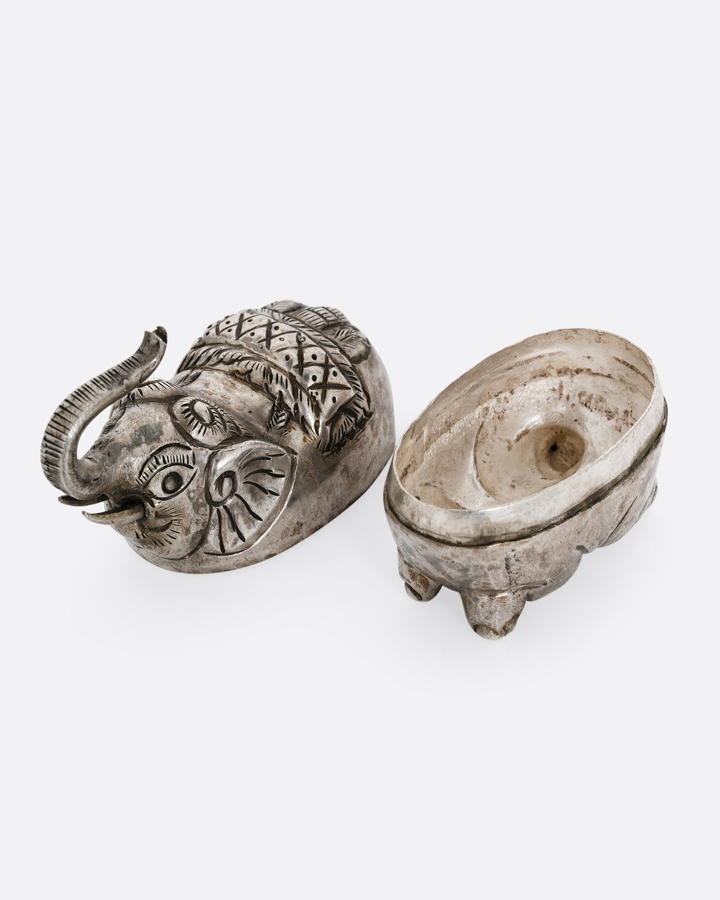 A silver elephant shaped box shown open from the top.