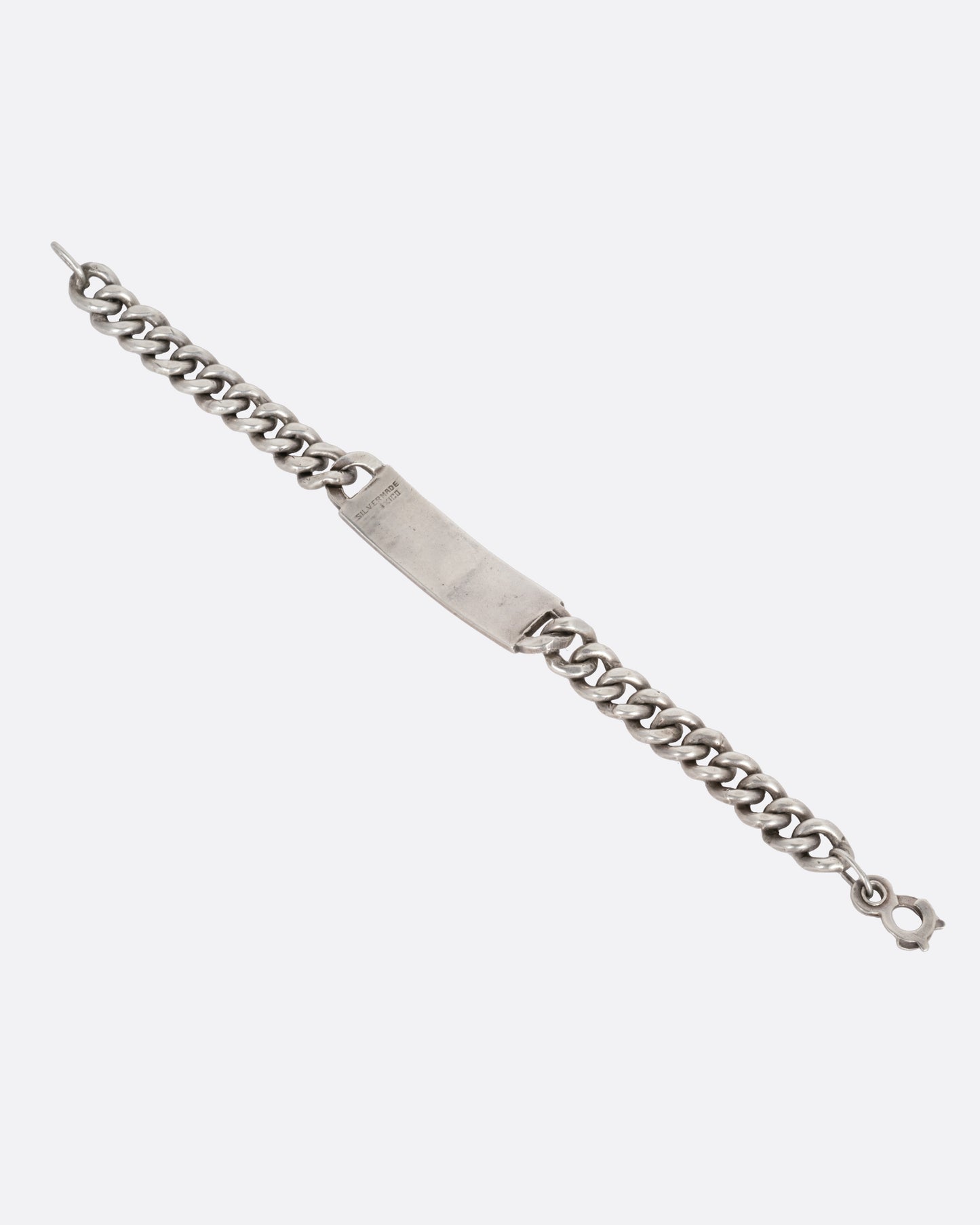 A silver curb chain ID bracelet, shown open from the back.