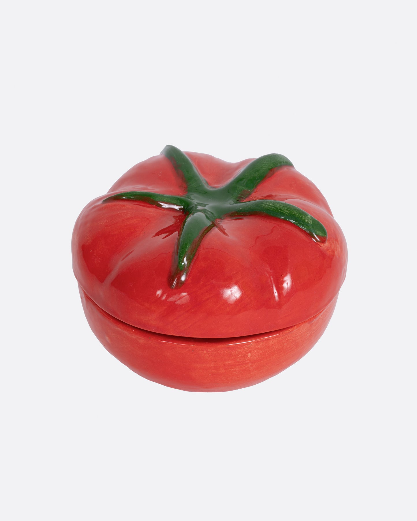 A tomato shaped salt cellar, shown from the front.