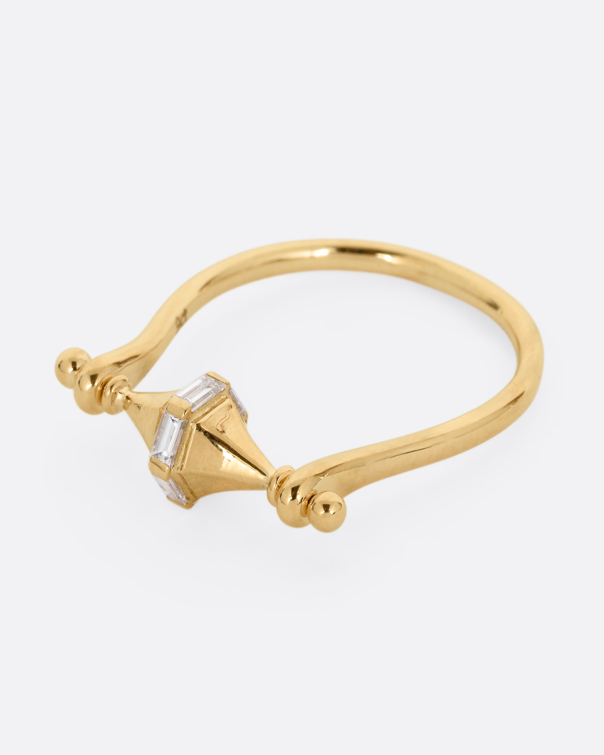 A yellow gold ring with a spin- able center and baguette diamonds. Shown from the side.