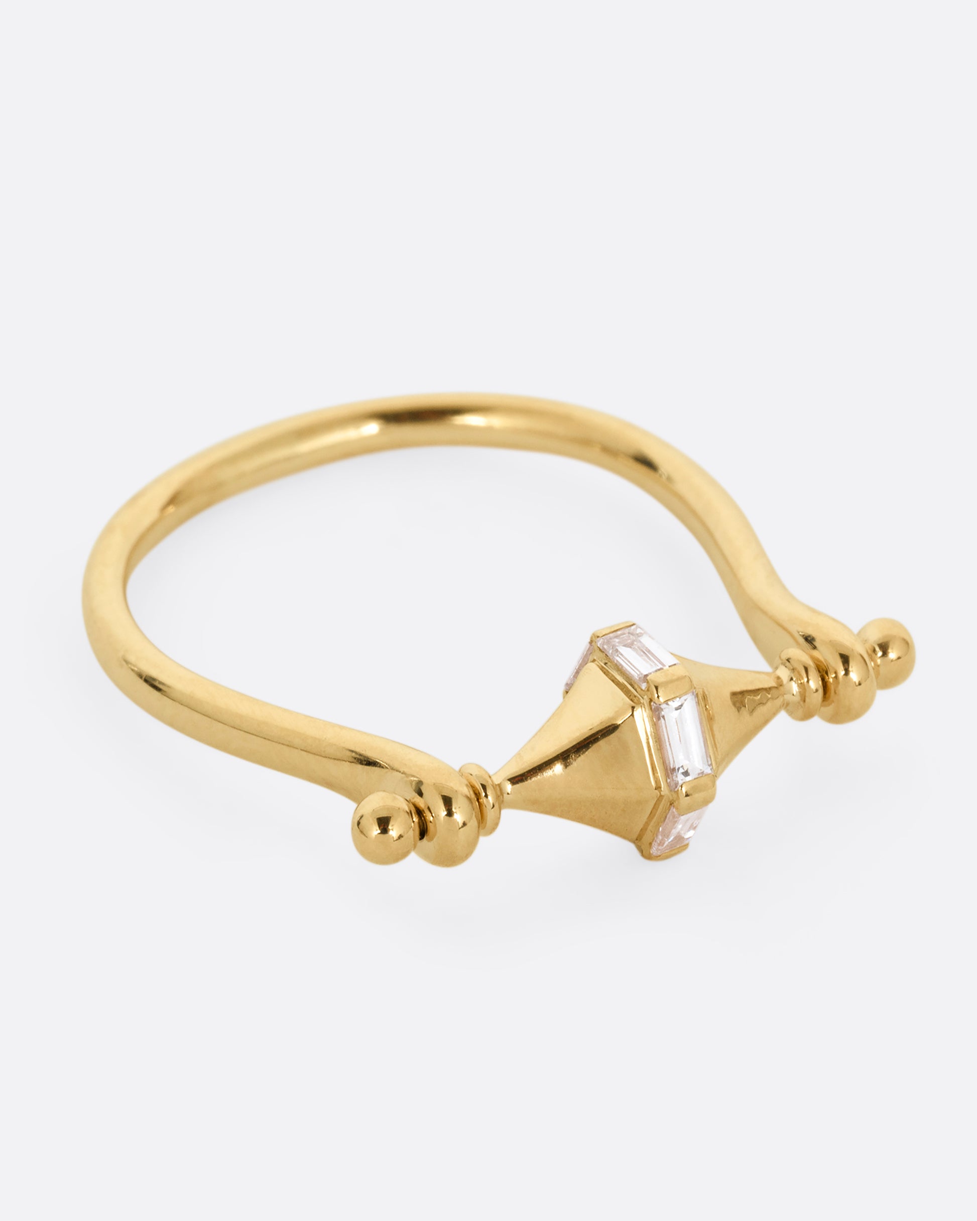 A yellow gold ring with a spin- able center and baguette diamonds. Shown from the side.