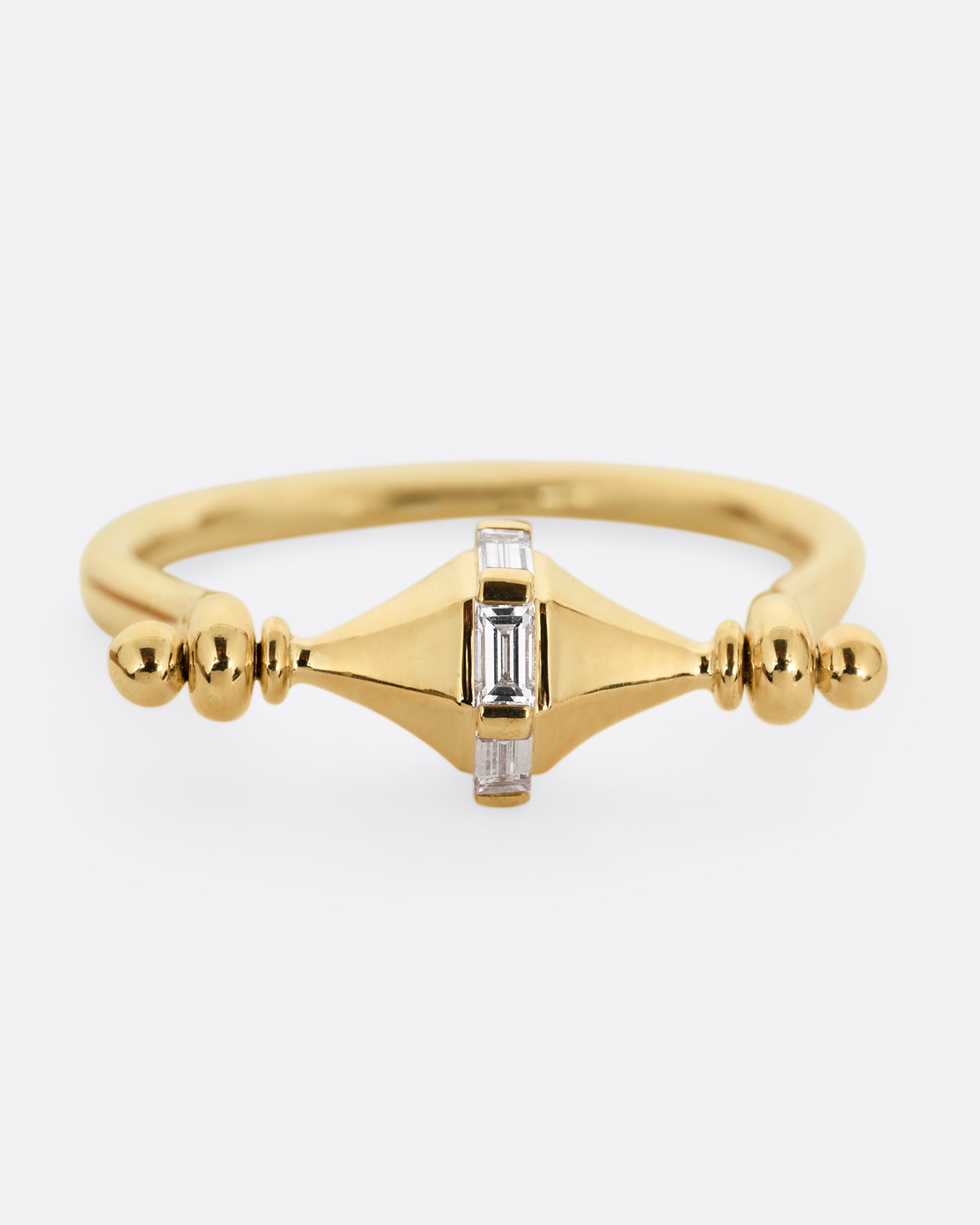 A yellow gold ring with a spin- able center and baguette diamonds. Shown from the front.