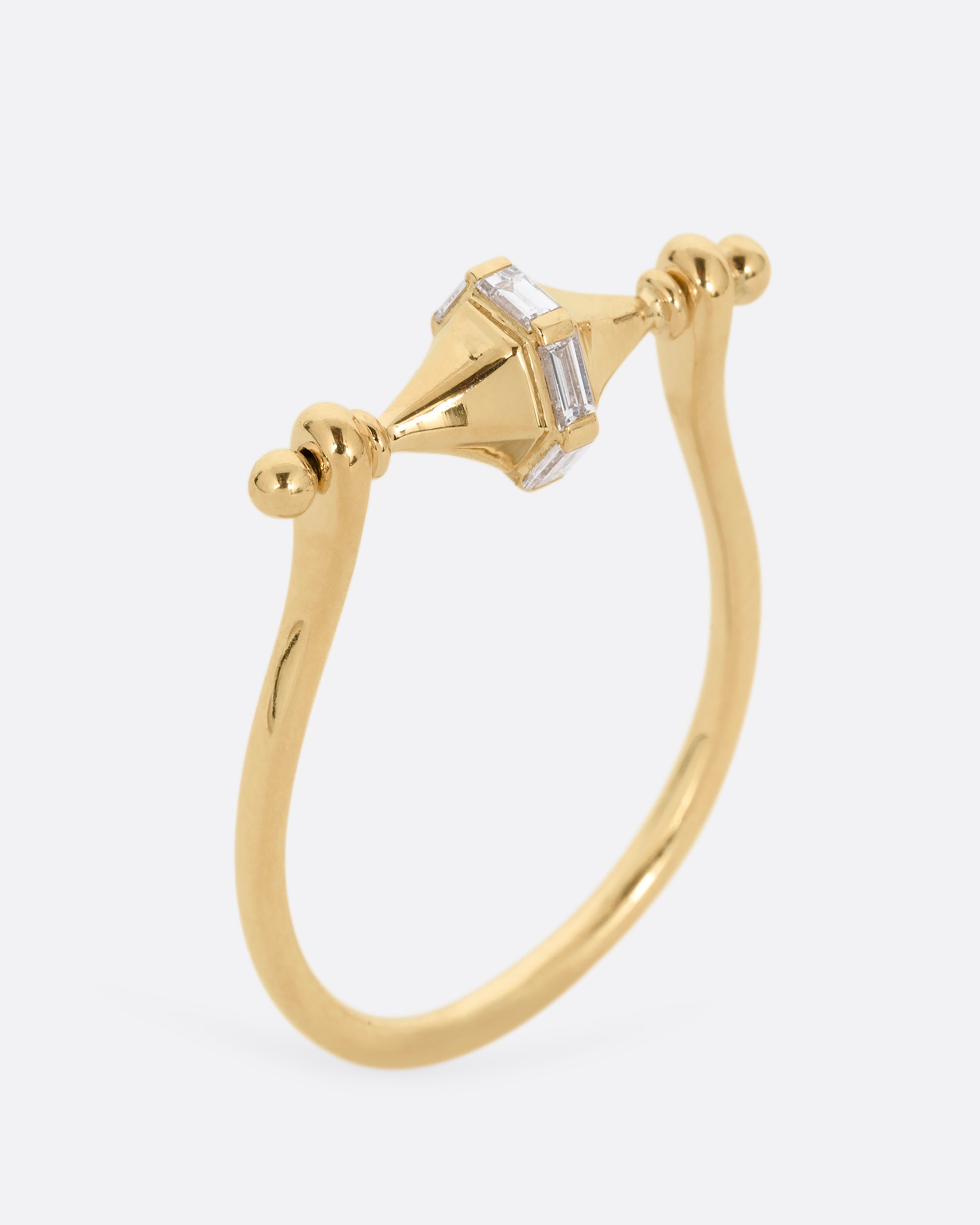 A yellow gold ring with a spin- able center and baguette diamonds. Shown standing up from the side.