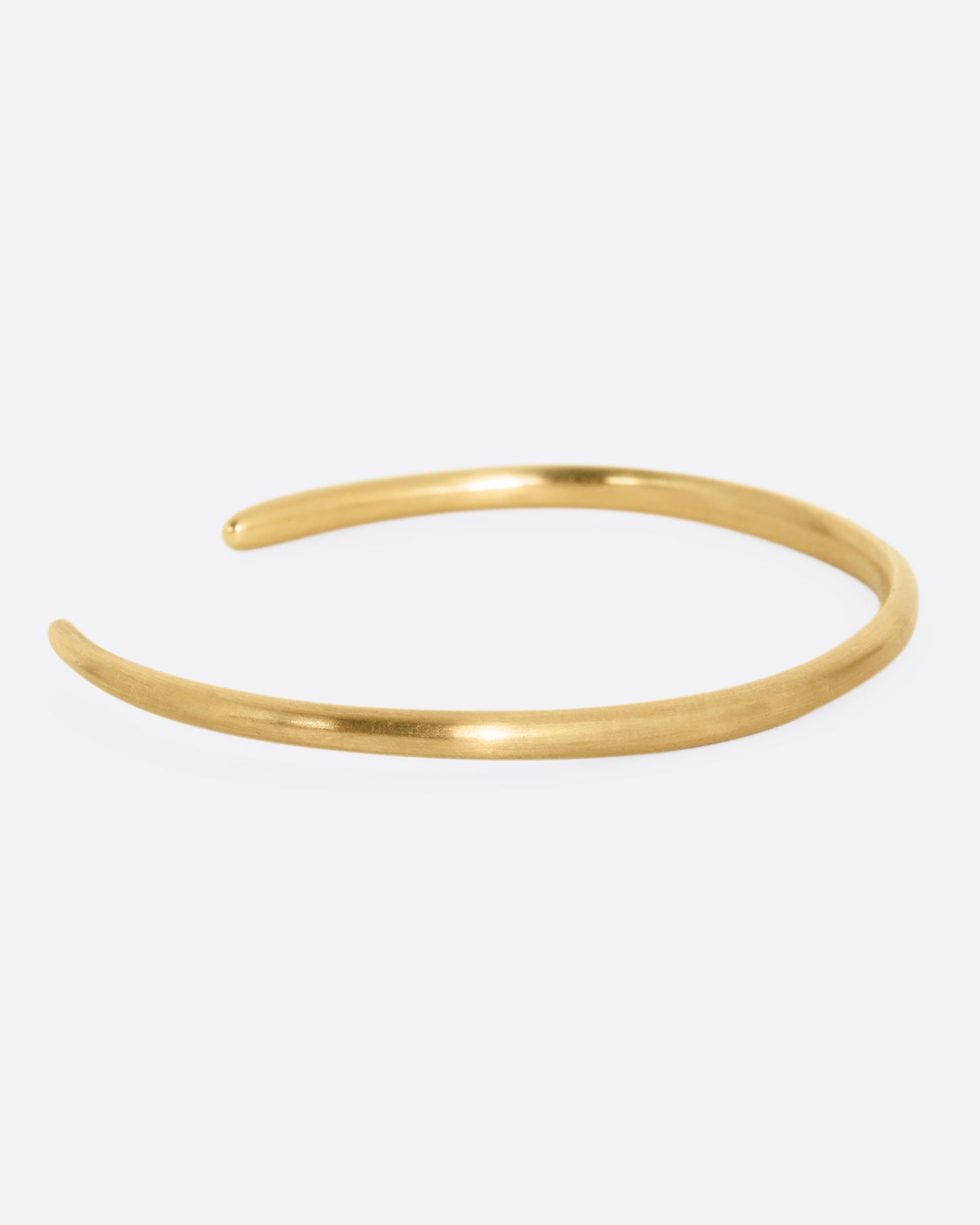 A yellow gold open cuff bracelet with diamonds. Shown from the back.