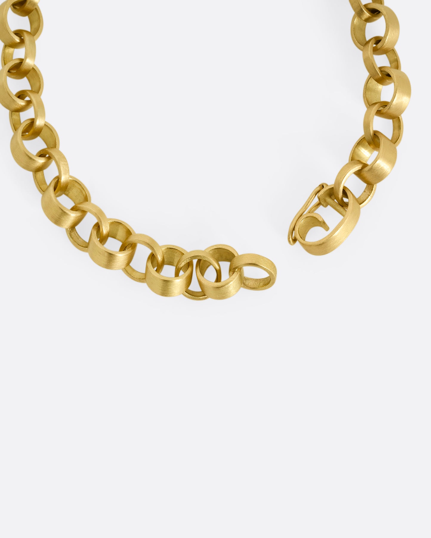 A close up of the clasp on a yellow gold bracelet with bicycle chain inspired links. Shown from the top.