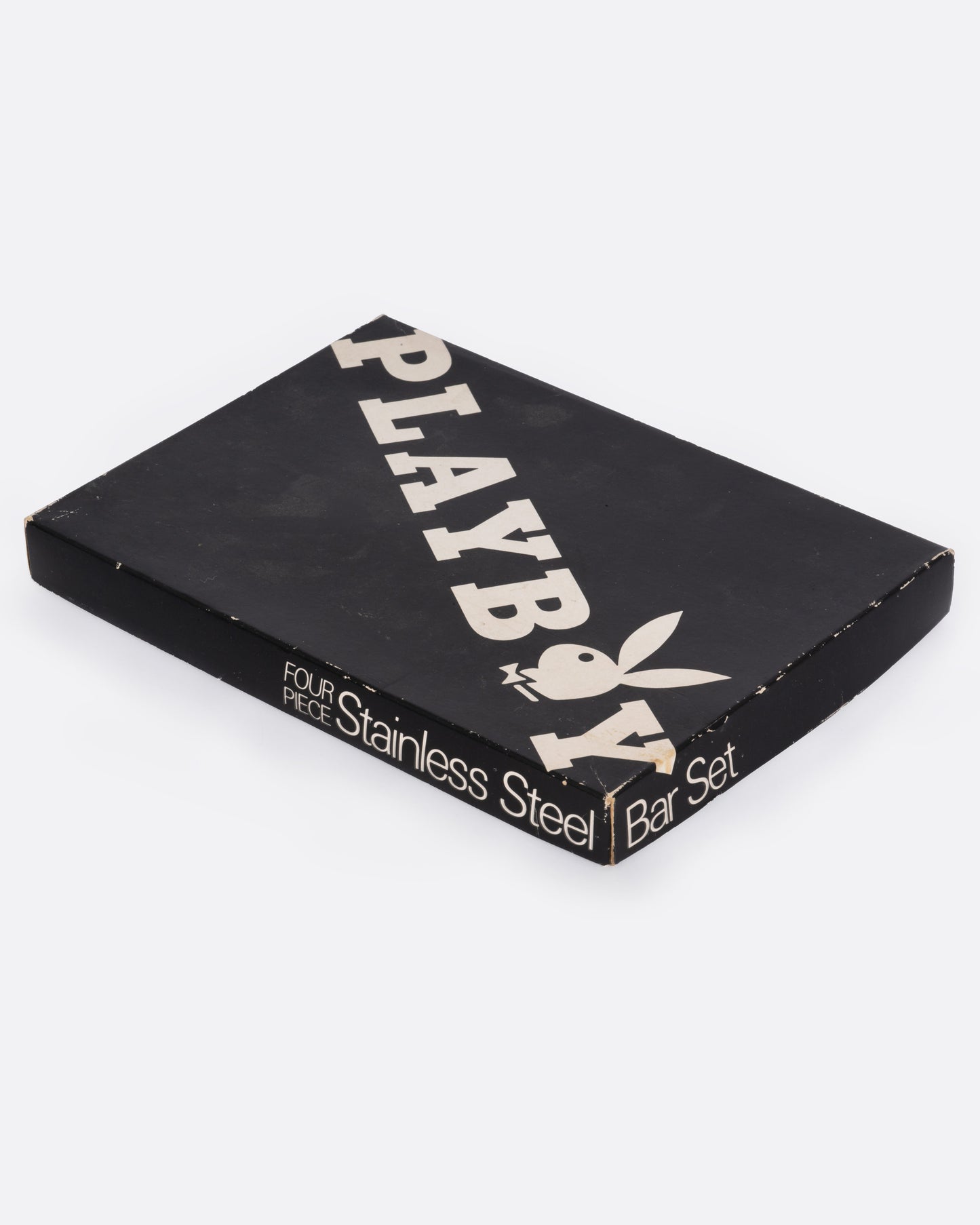 A playboy stainless steel bar set in a black box with white writing, shown from the side.