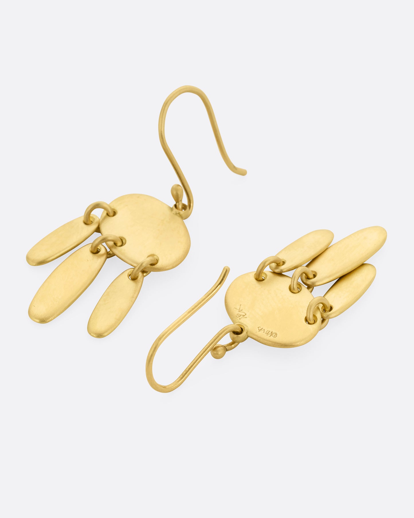 A pair of yellow gold earrings; each with one horizontal oval and three vertical ovals hanging from links. One earring is shown lying flat from the front, the other from the back.