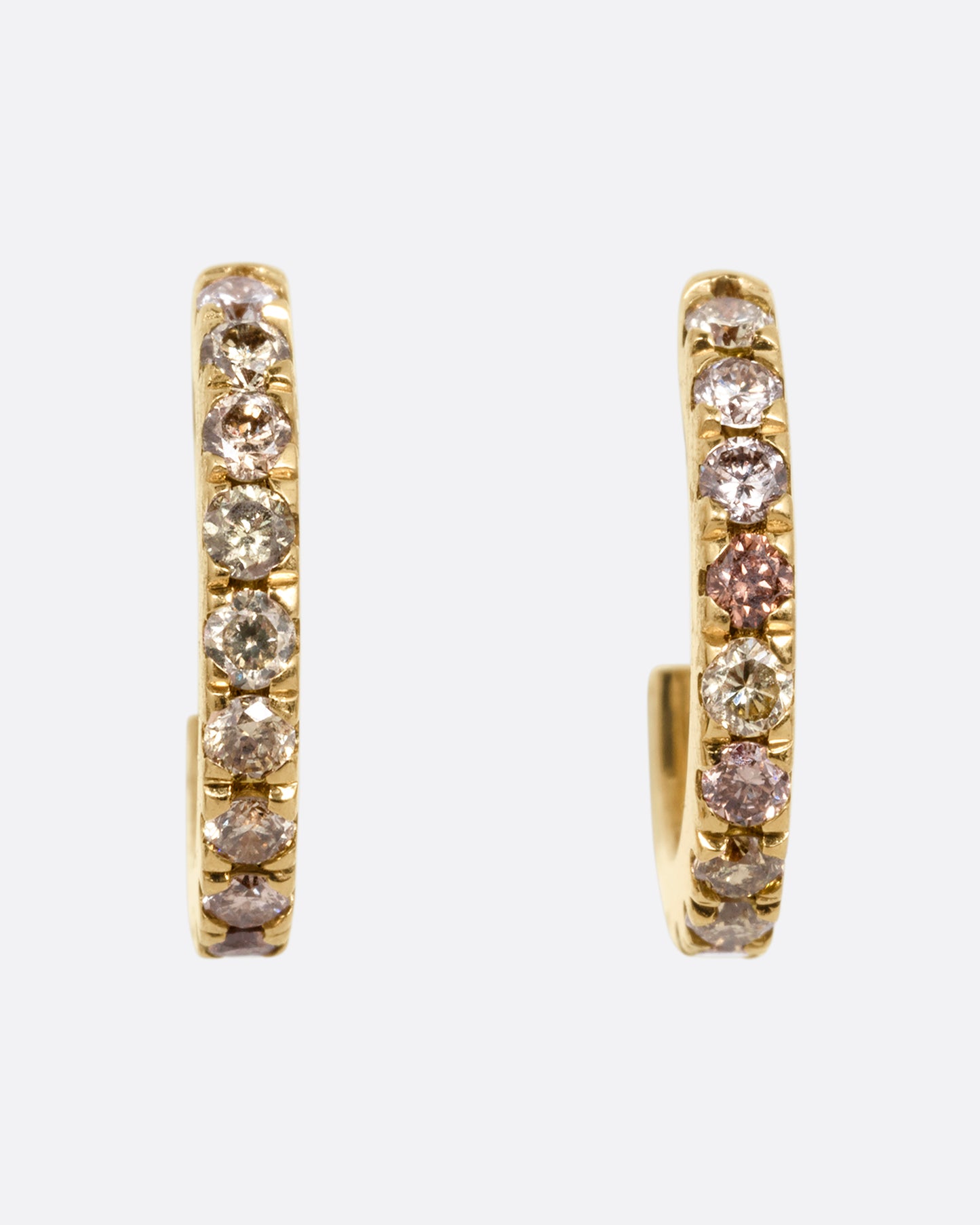 Small yellow gold hoops with green and brown pave diamonds. Shown from the front.