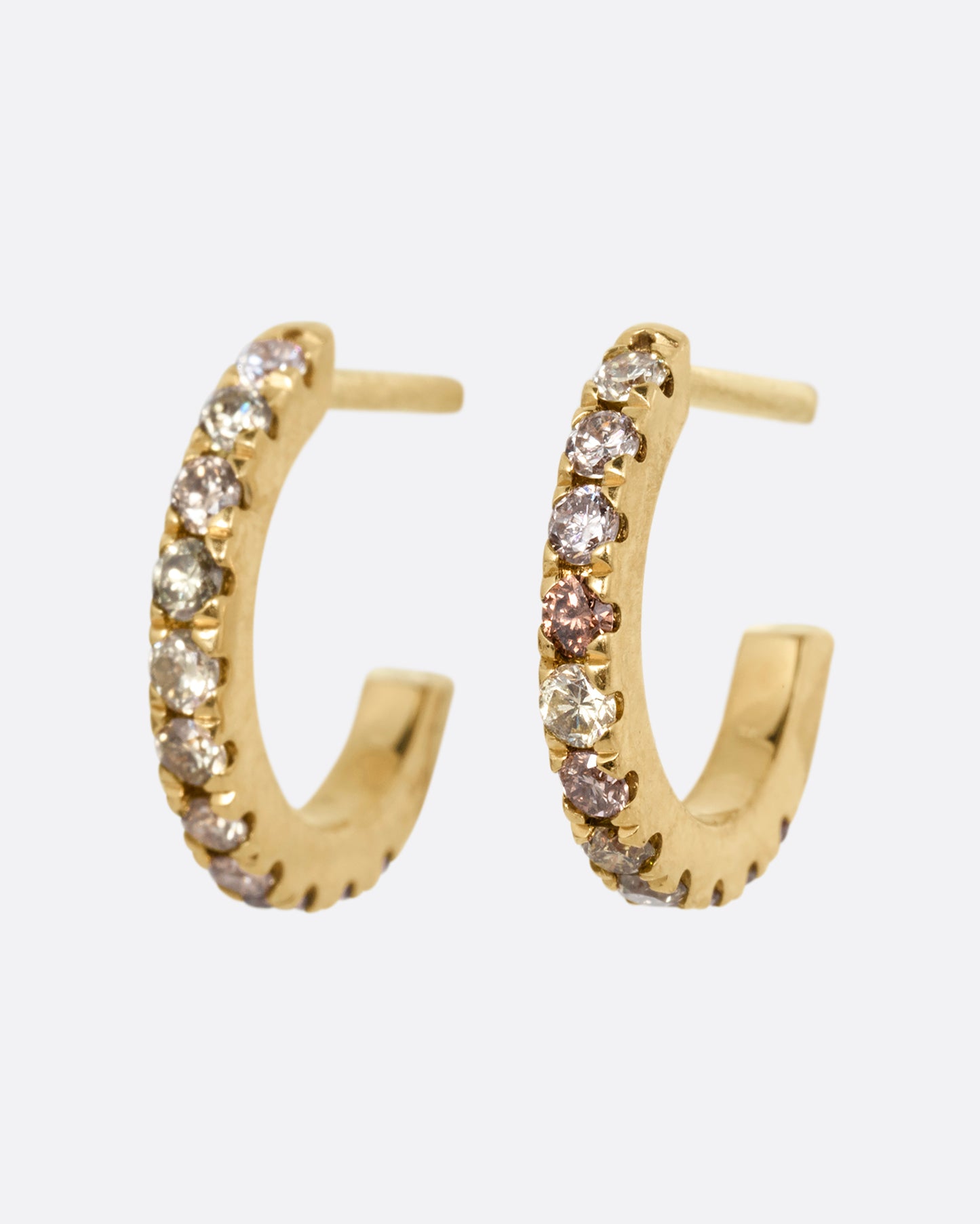 Small yellow gold hoops with green and brown pave diamonds. Shown from the side.