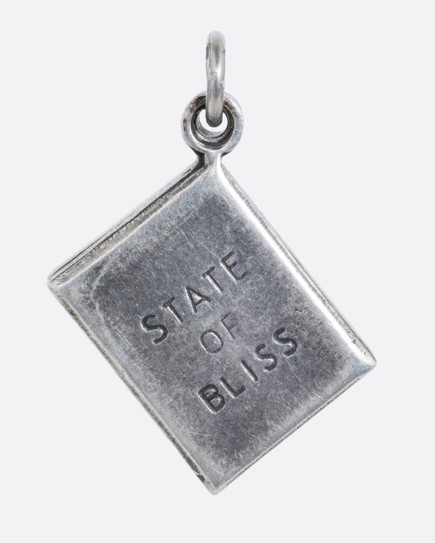 A silver marriage license charm with a red heart on the front and 'State of Bliss' on the back. Shown from the back.