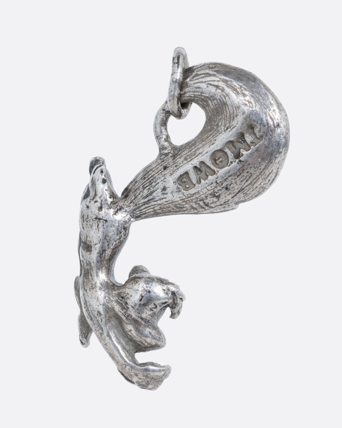 A silver Pepe Le Pew charm. Shown from the back.