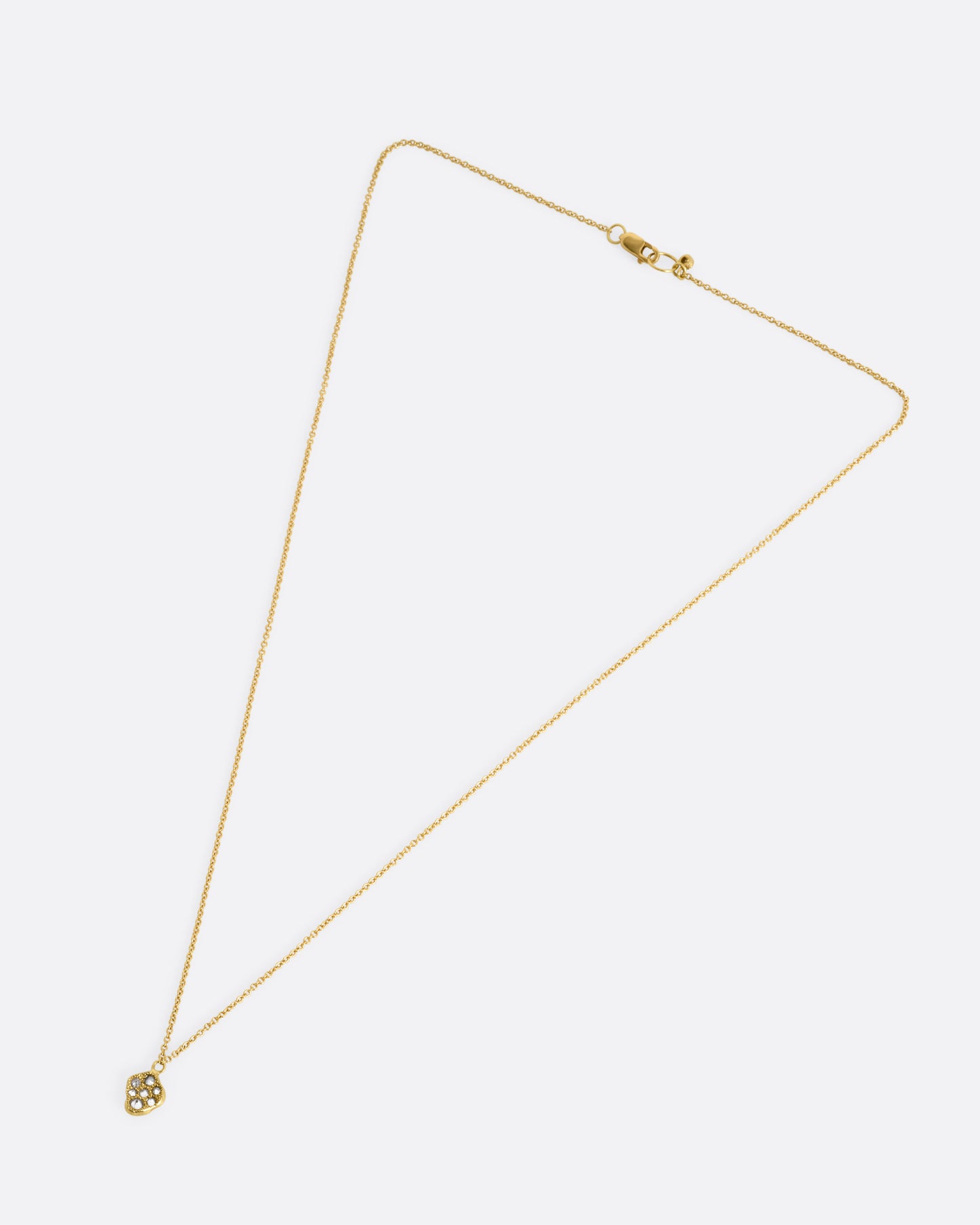 A yellow gold necklace with a concave textured pendant with inverted diamonds. Shown from the front.