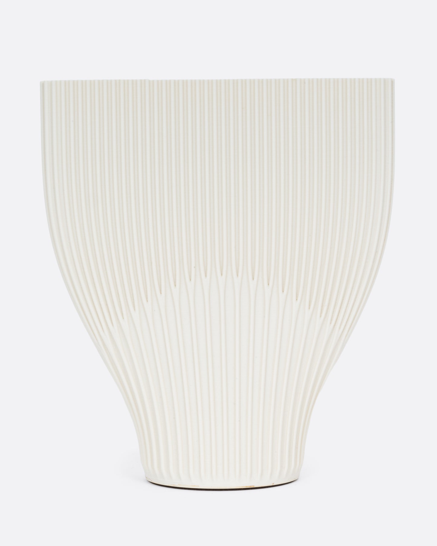 A ribbed cream 3D printed vase with a wide top and narrow base. Shown from the front.
