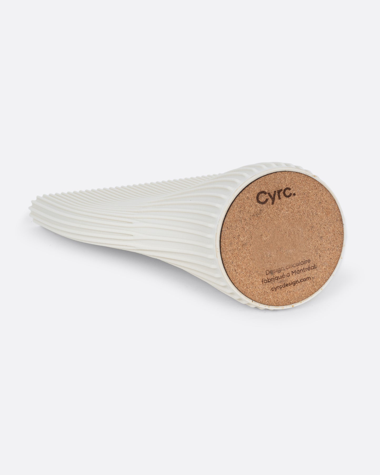 A ribbed cream 3D printed vase with a wide top and narrow base. Shown lying on its side from the bottom.