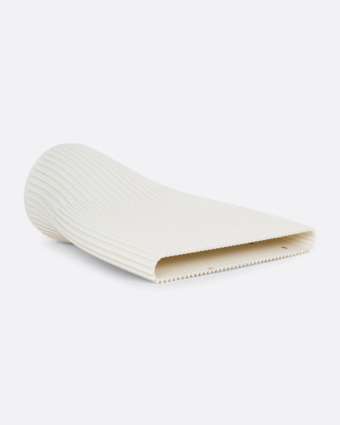 A ribbed cream 3D printed vase with a wide top and narrow base. Shown lying on its side from the top.