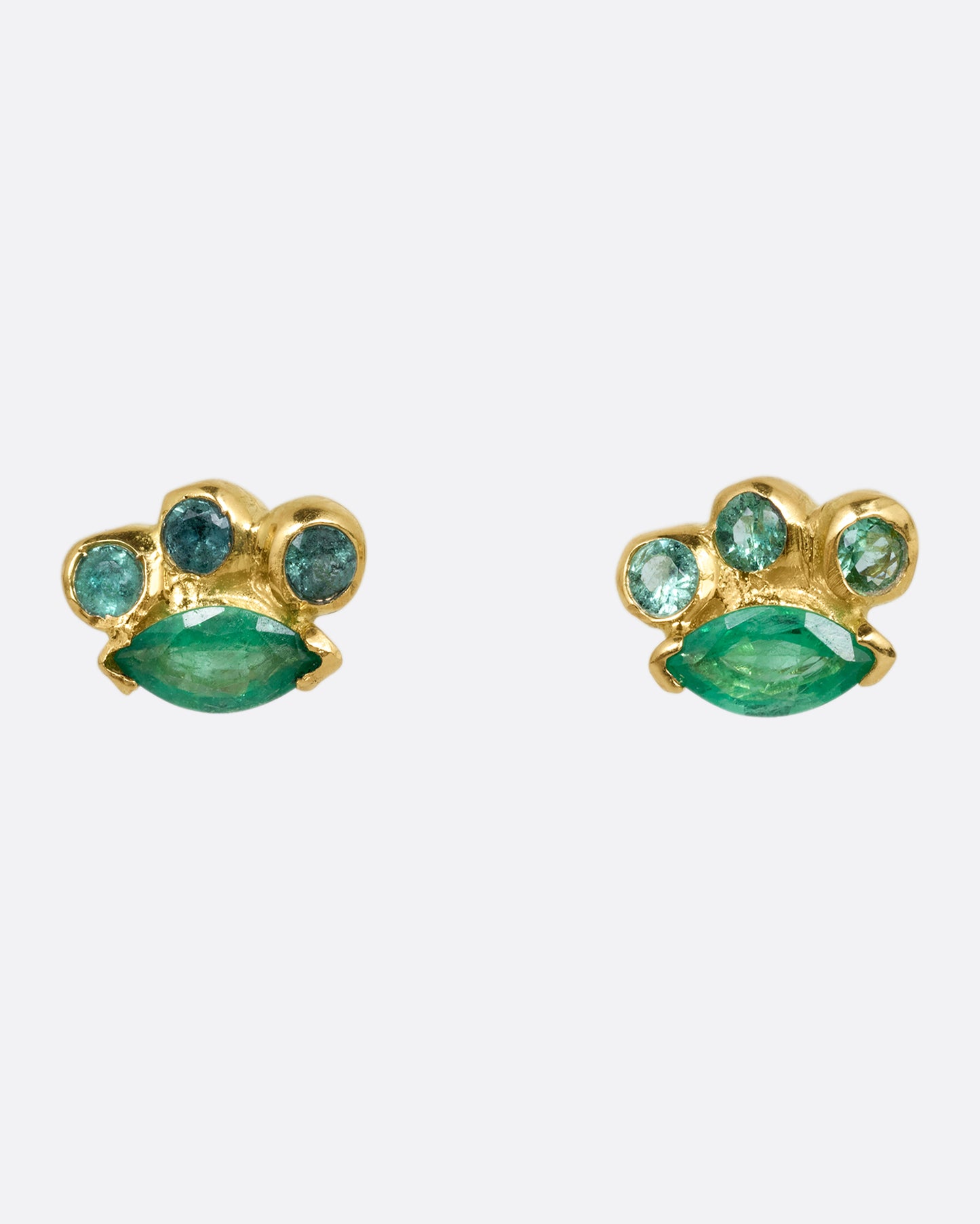 A pair of yellow gold stud earrings with round and marquise emeralds. Shown from the front.