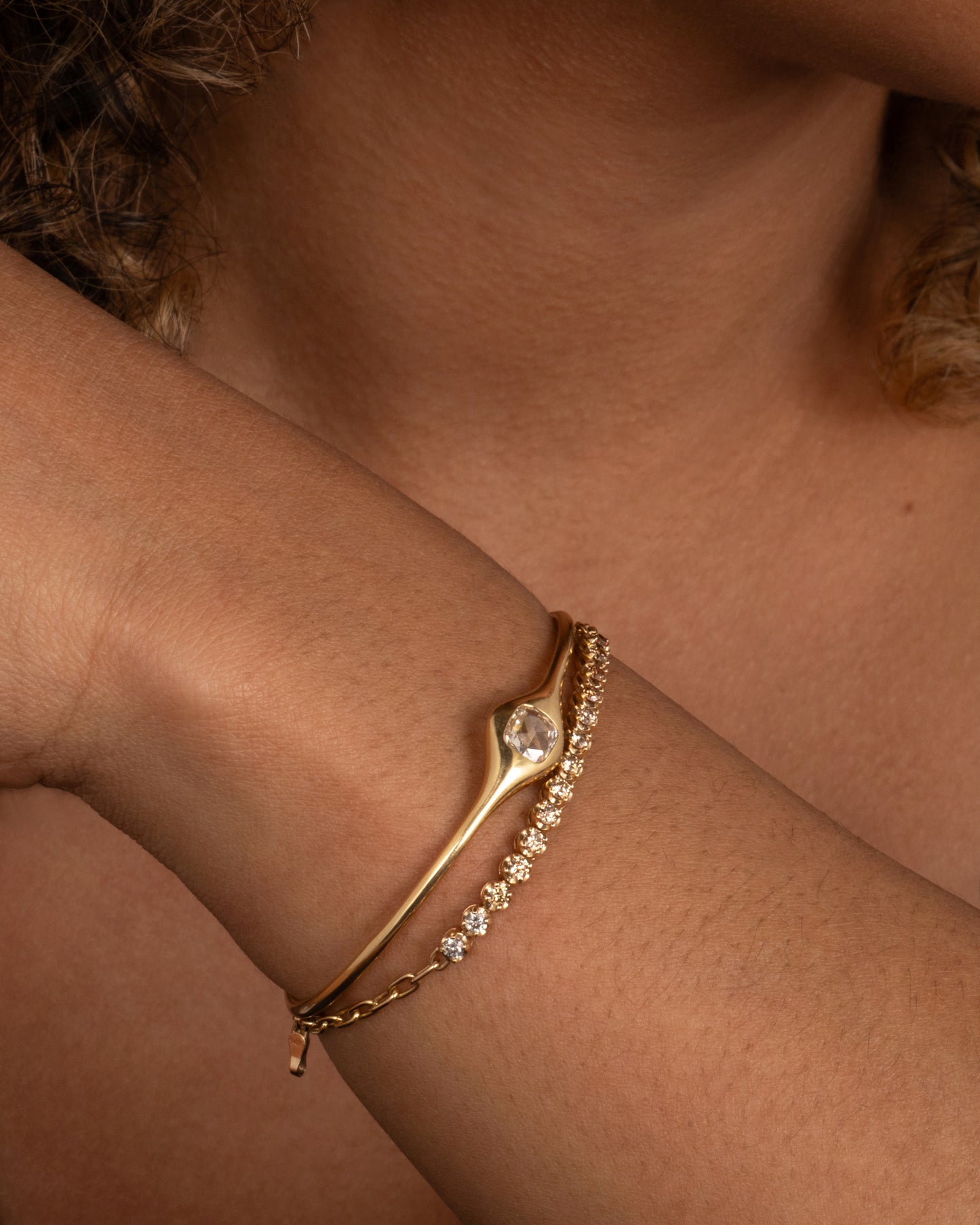 A partial tennis bracelet with a mix of light & dark champagne and gray diamonds set in darkened settings so they really glow. Shown worn around a wrist paired with Diana Mitchell cuff.