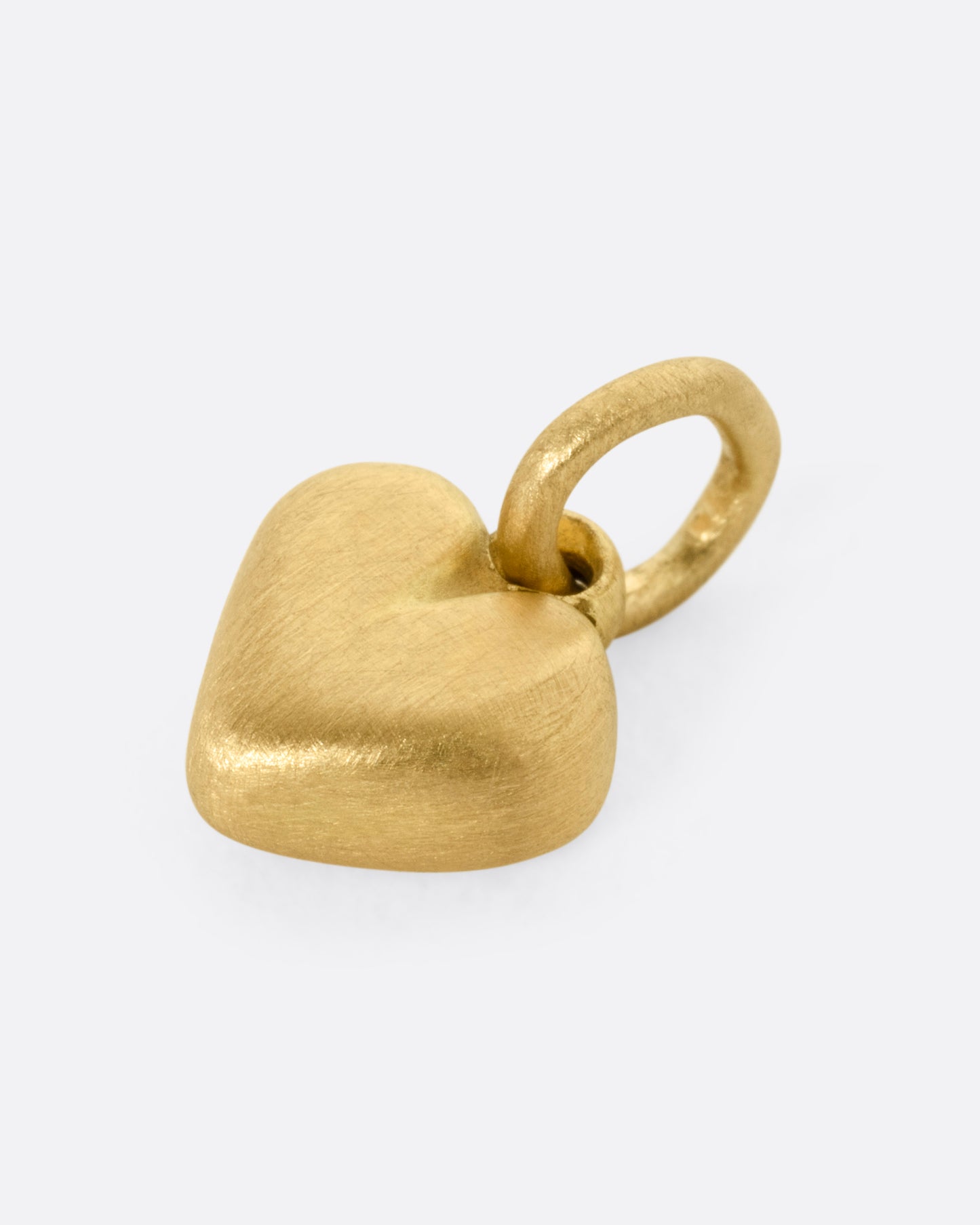 A yellow gold heart-shaped pendant shown from the side.