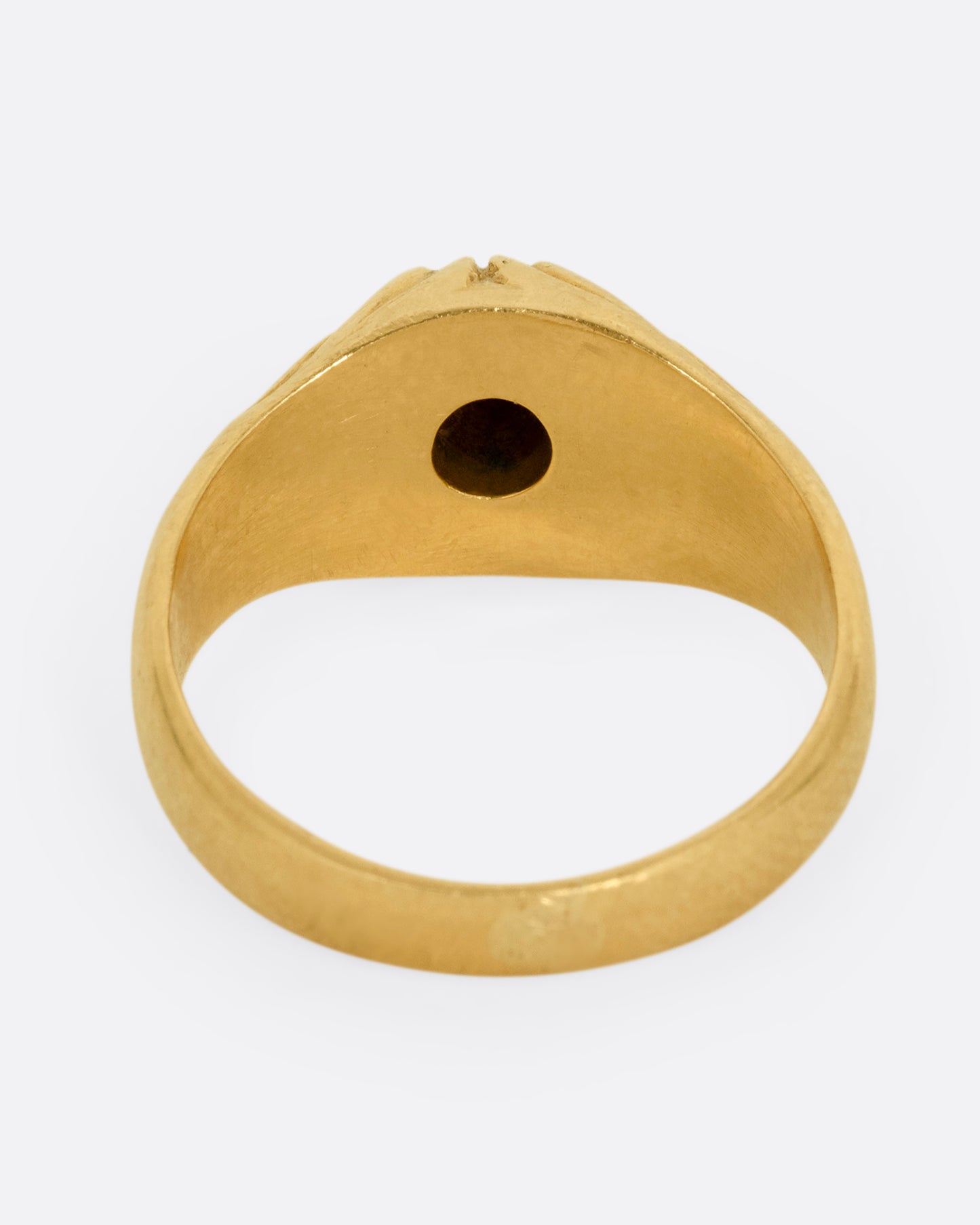 A yellow gold dome ring with textural waves on its top and a round central diamond. Shown from the back.