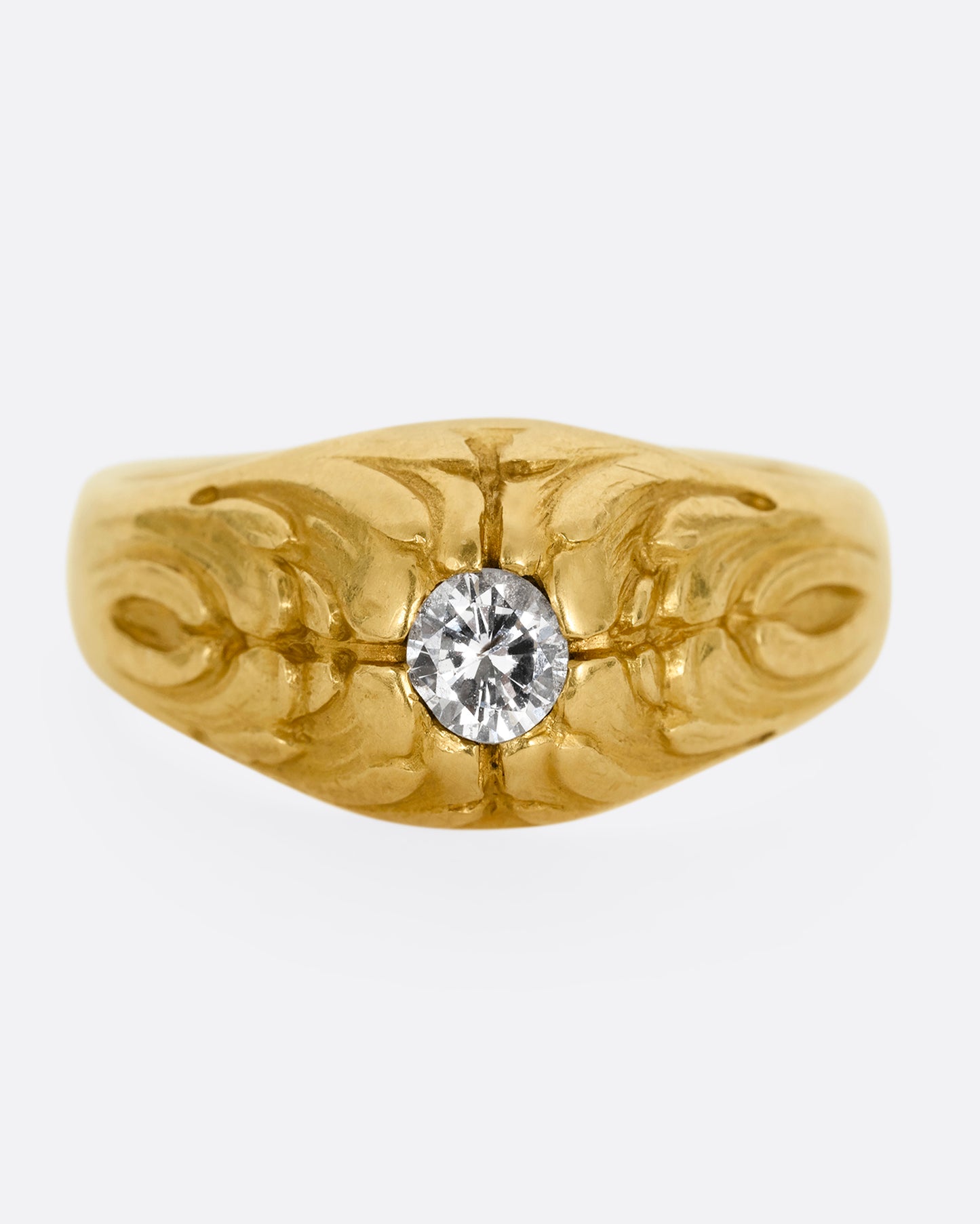 A yellow gold dome ring with textural waves on its top and a round central diamond. Shown from the front.