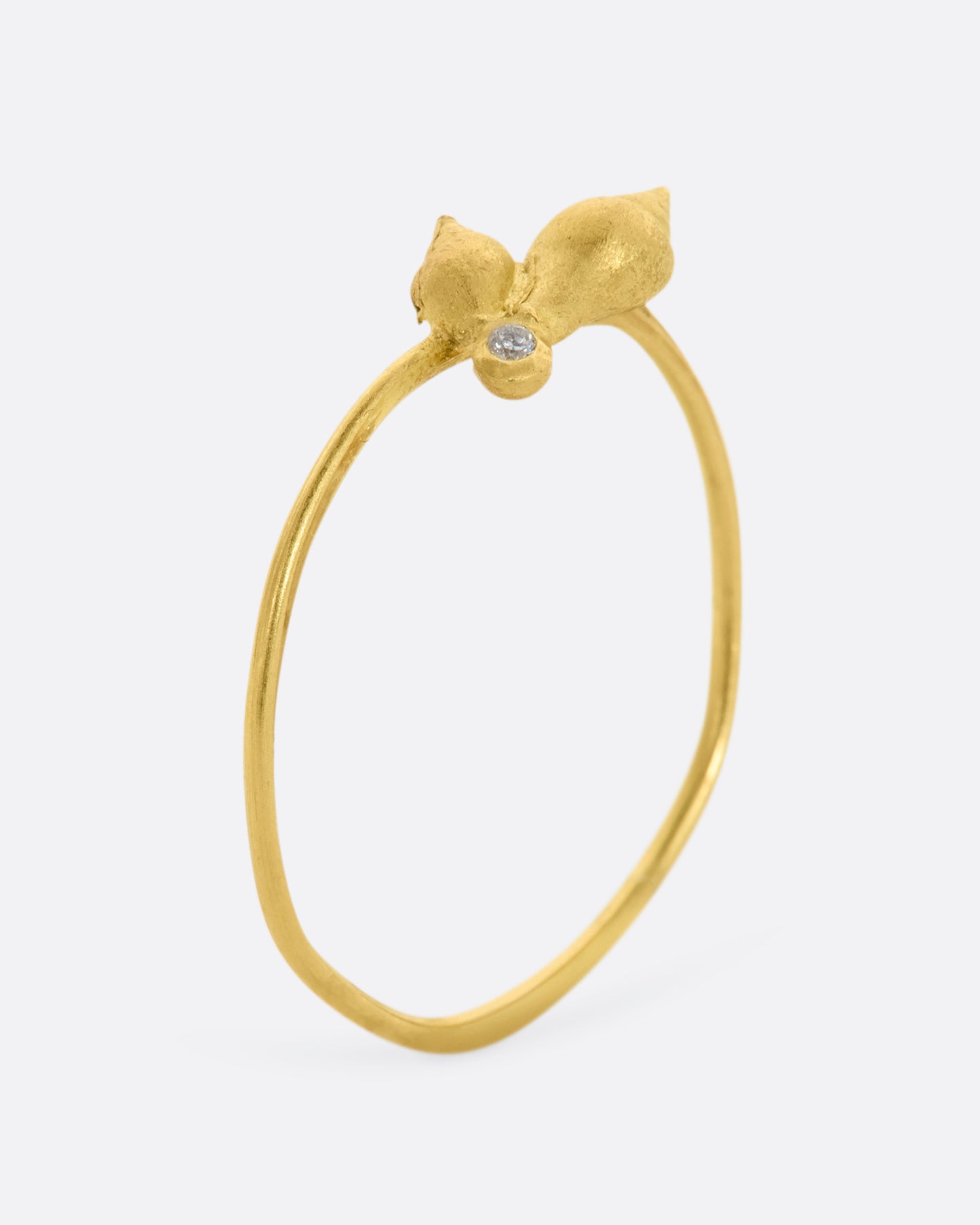 A ring with a cluster of two seashells and a diamond on a dainty band. View standing up.