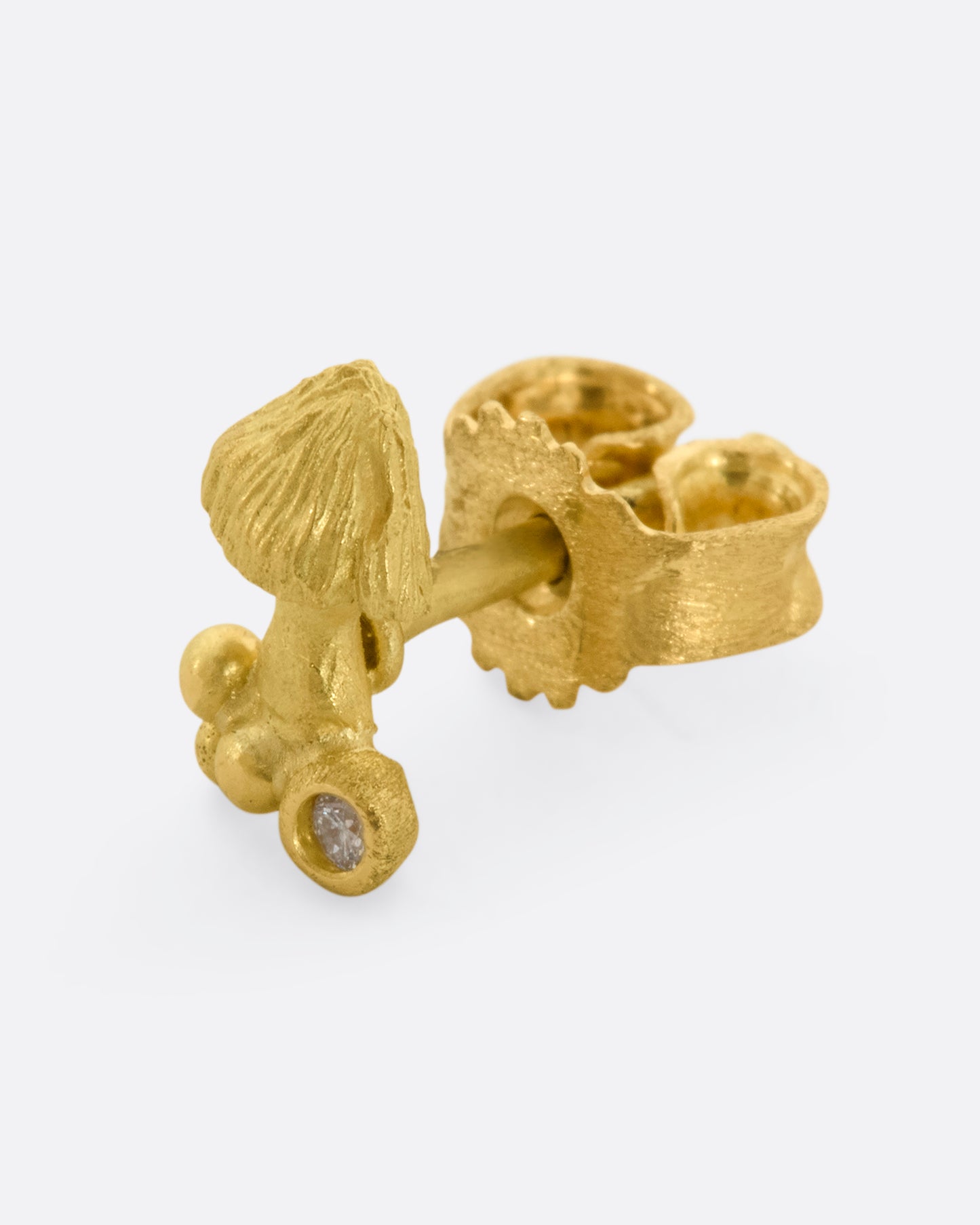Yellow gold mushroom cluster with diamond below the stem. View from the side.