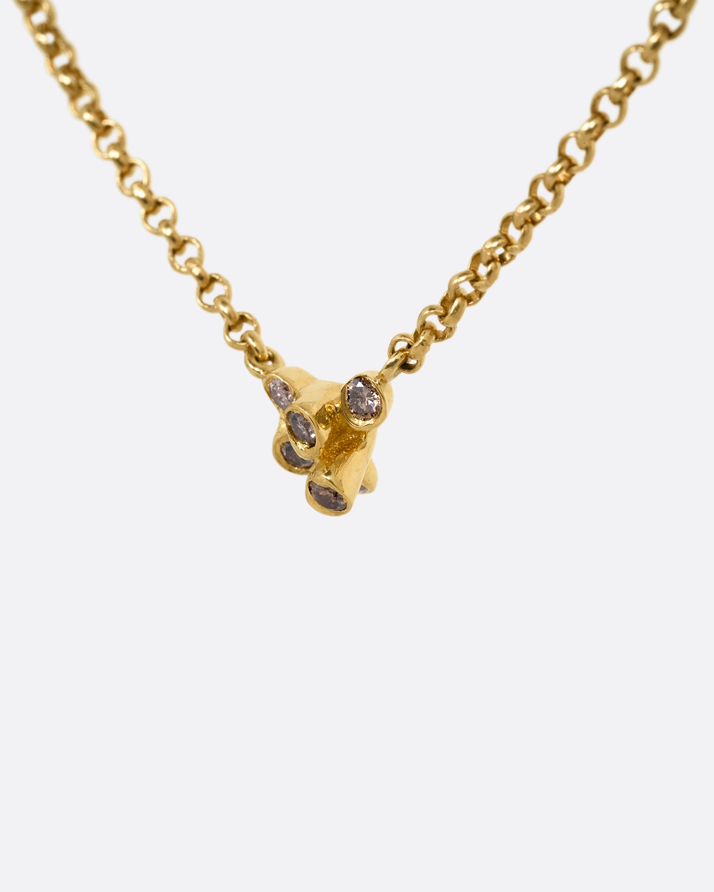 A yellow gold cable chain necklace with a central cluster of dimensional cognac diamonds. Shown from the side.