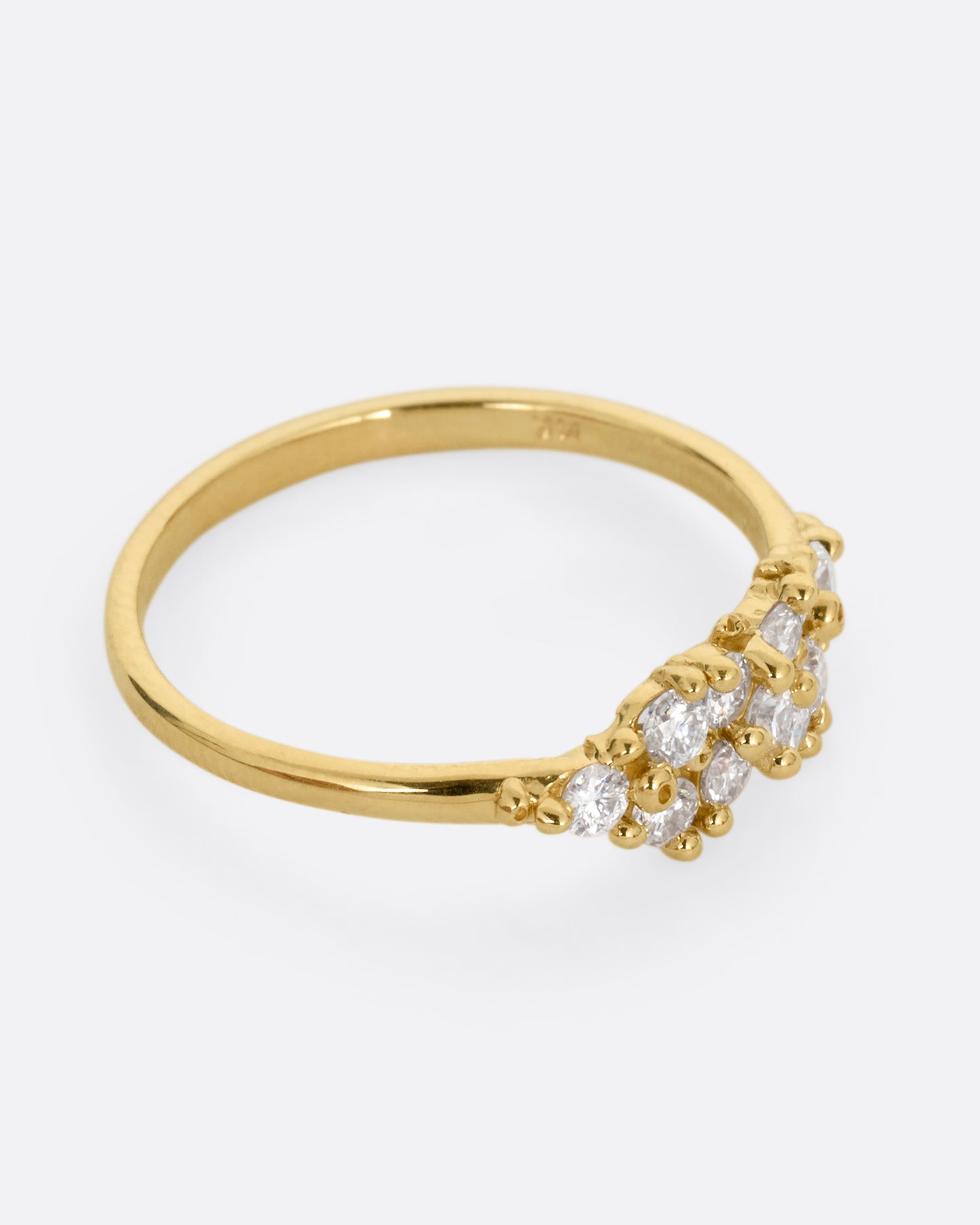 A yellow gold ring with a large cluster of diamonds and tiny gold droplets. Shown from the side.
