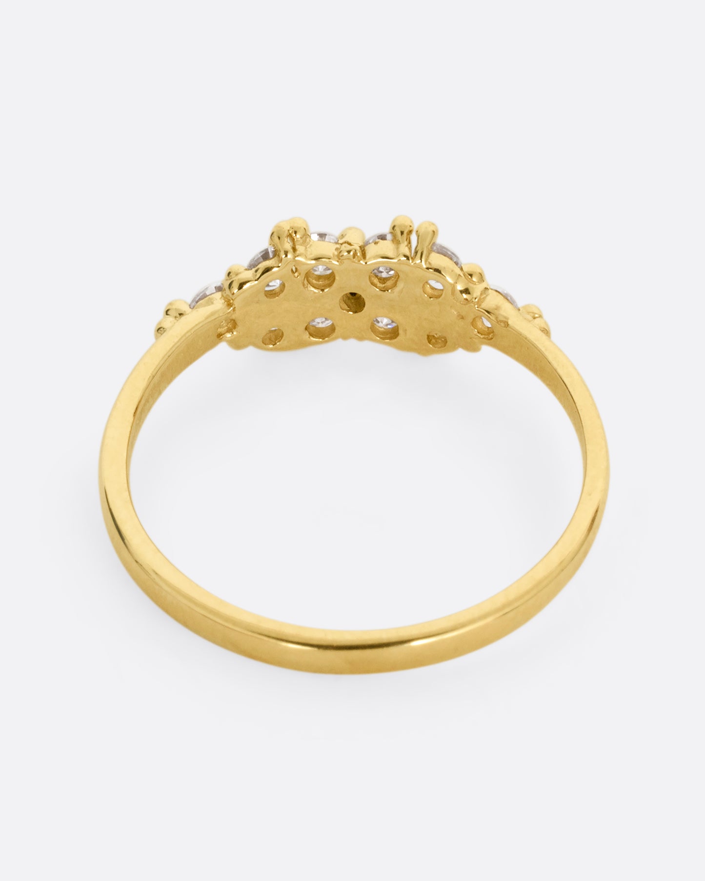 A yellow gold ring with a large cluster of diamonds and tiny gold droplets. Shown from the back.