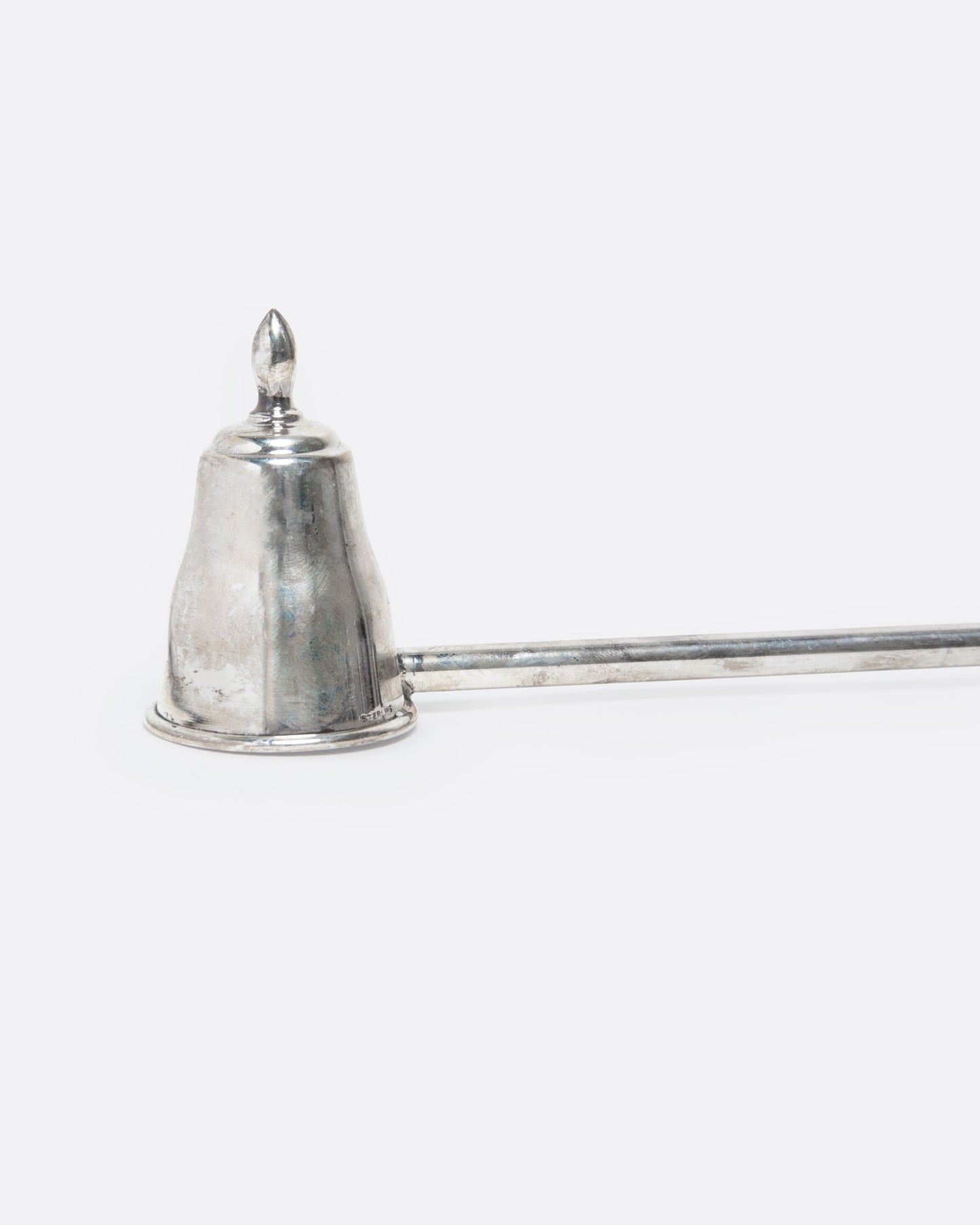 A sterling silver candle snuffer with a black wooden handle, shown close up.