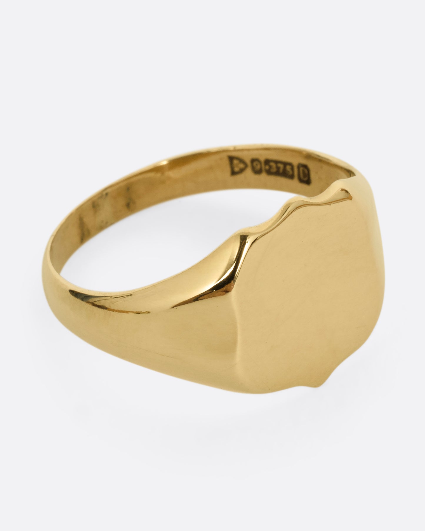 A yellow gold shield shaped signet ring. Shown from the front.