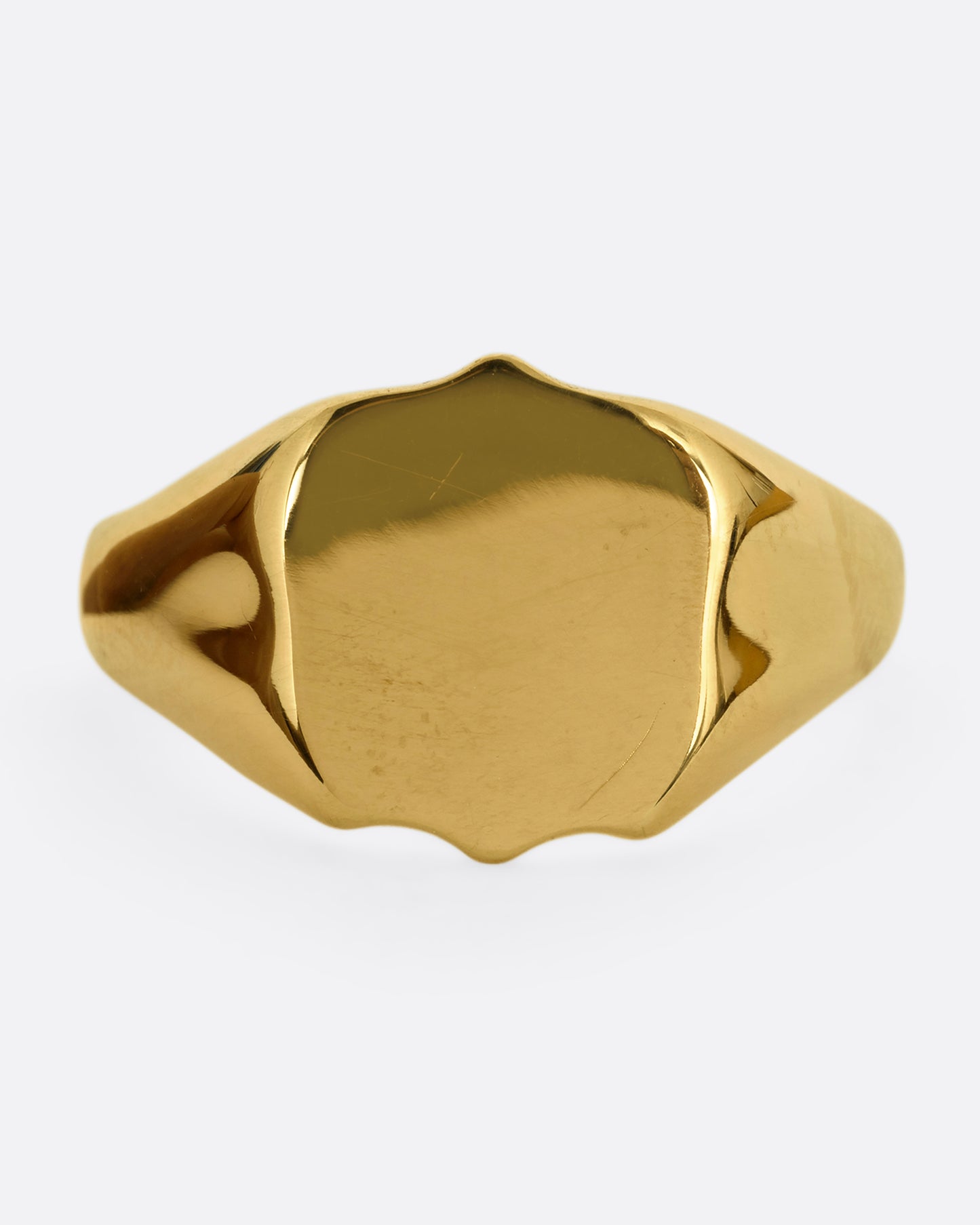 A yellow gold shield shaped signet ring. Shown from the front.