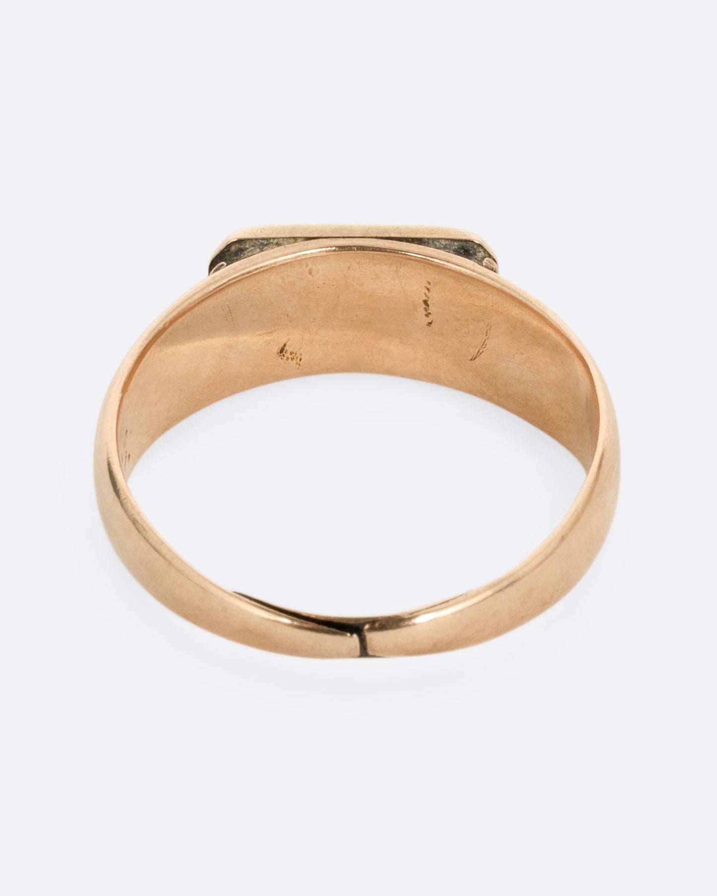 A yellow gold signet ring with a rectangular face. Shown from the back.