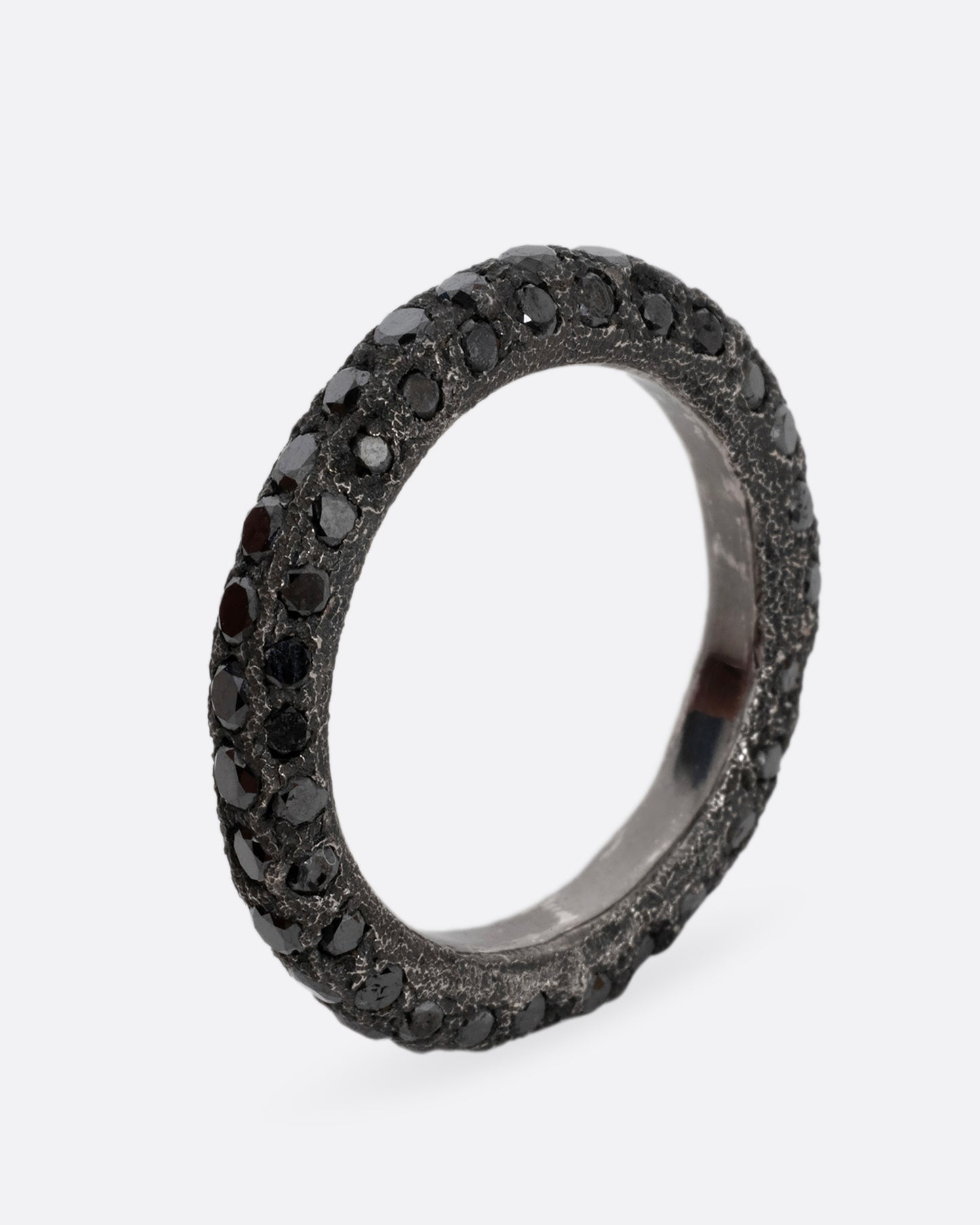 A darkened palladium band with black diamonds. Shown standing up from the side.