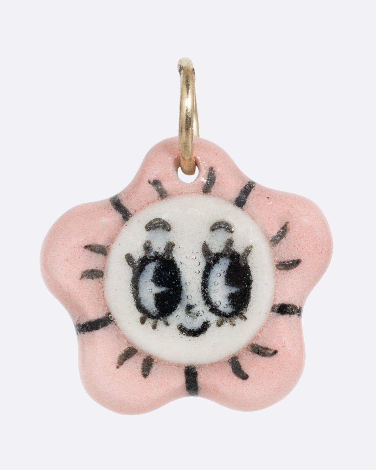A pink flower porcelain flower charm with a face at the center. Shown from the front.