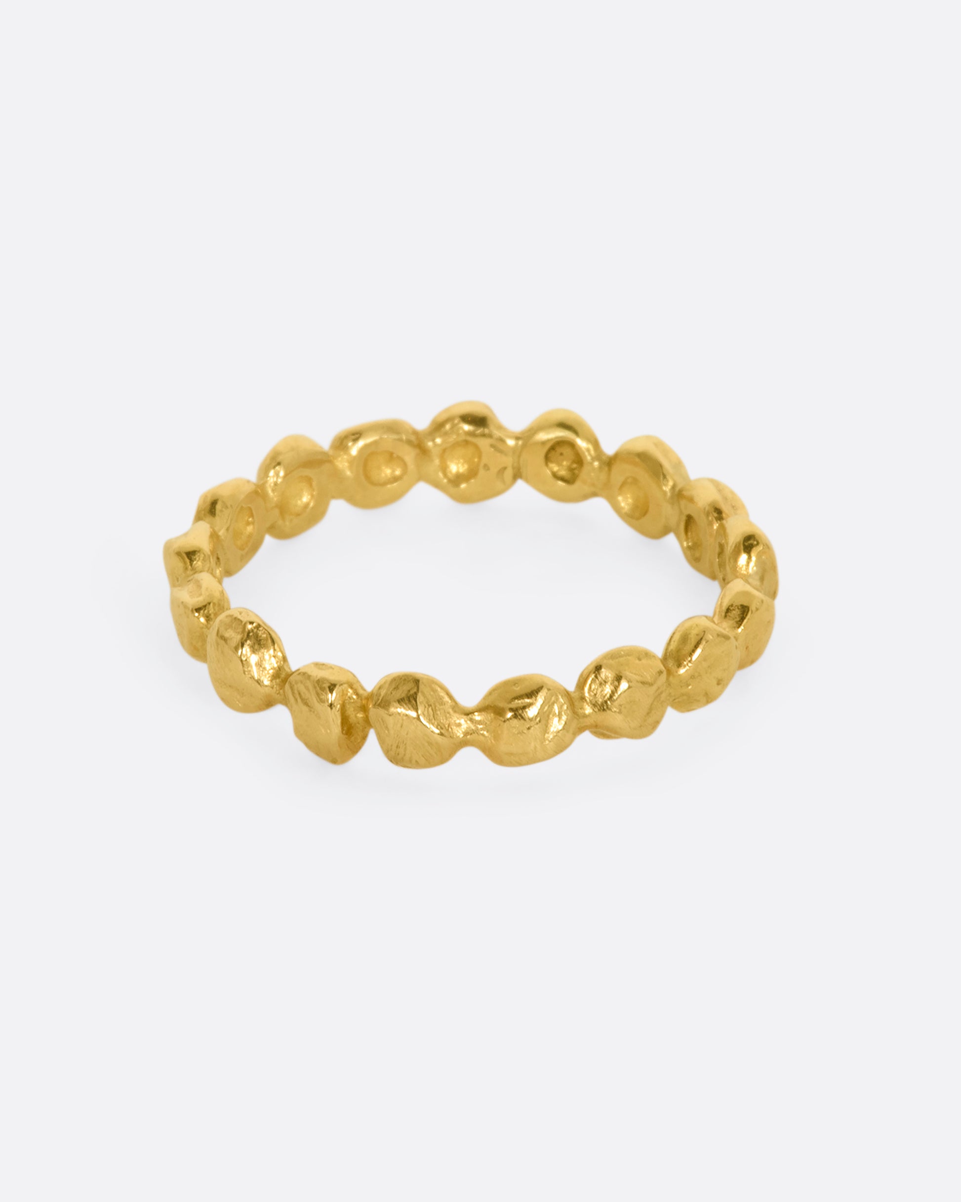 A yellow gold textured dot eternity band.