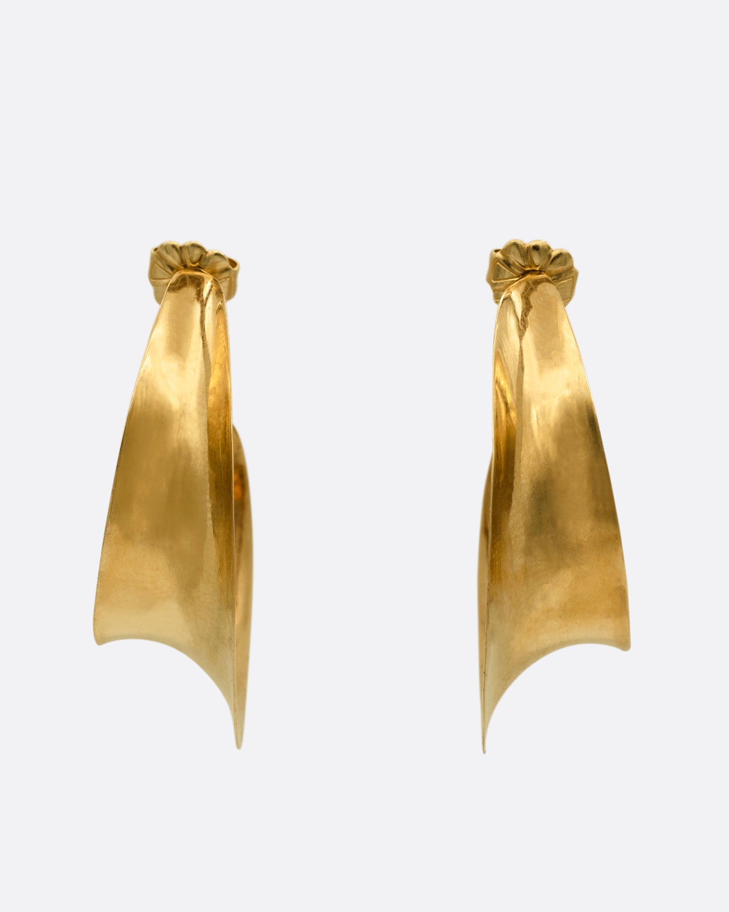 Yellow gold hoop earrings with a ribbon- like shape. Shown from the front.