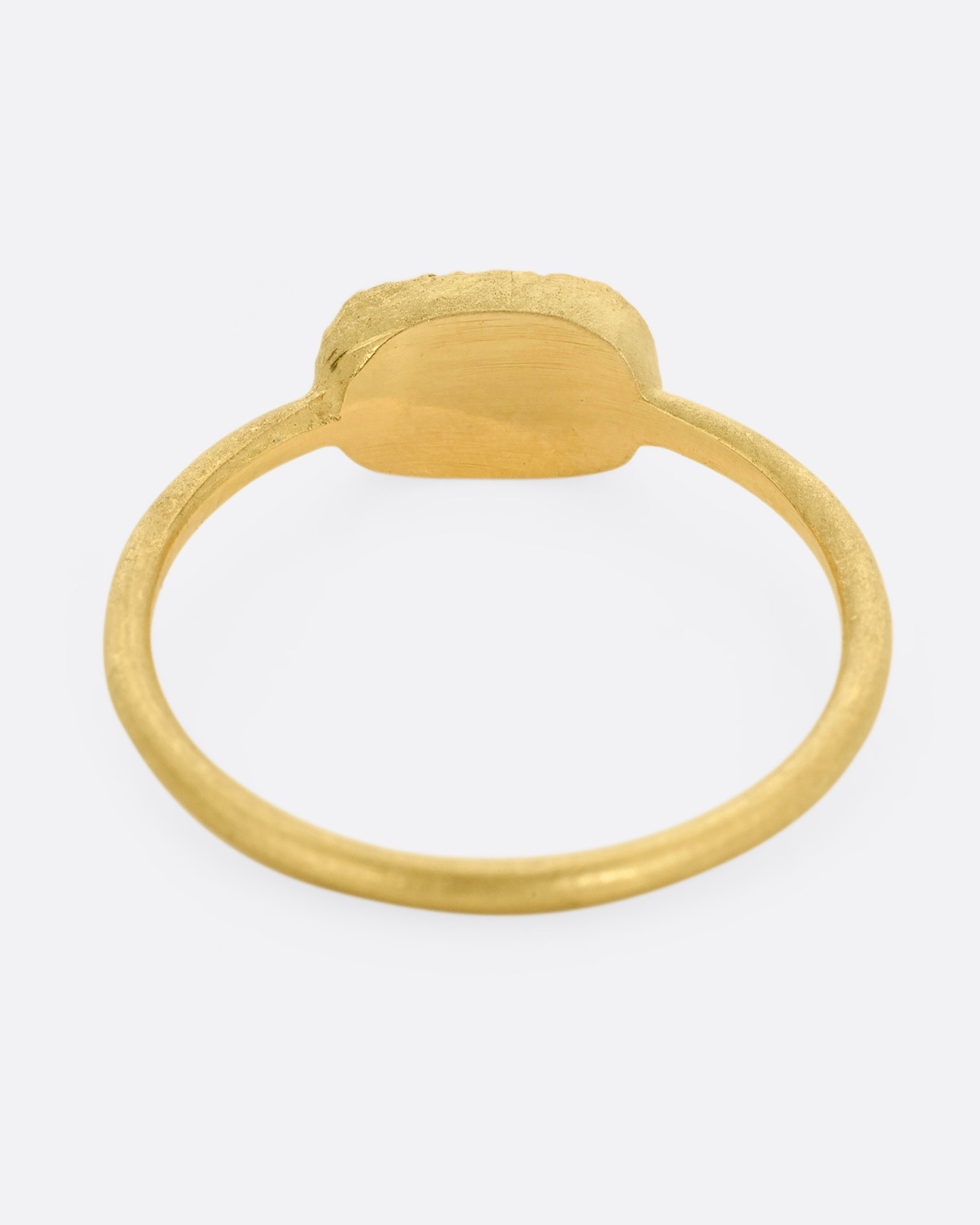 A yellow gold ring with a textured oval face with twelve white diamonds, shown from the back.