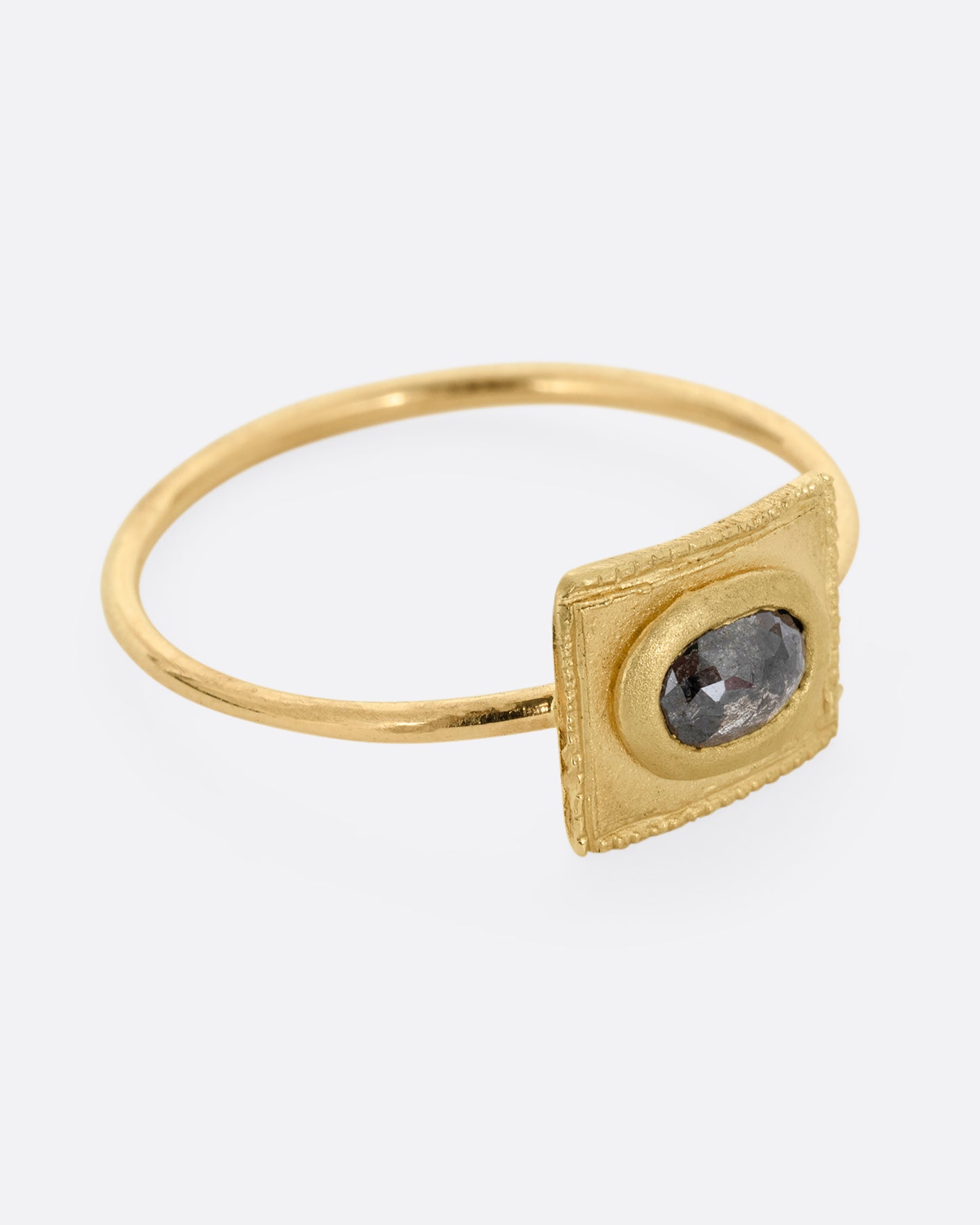 A yellow gold ring with a rectangular face and a rose cut diamond. Shown from the side.