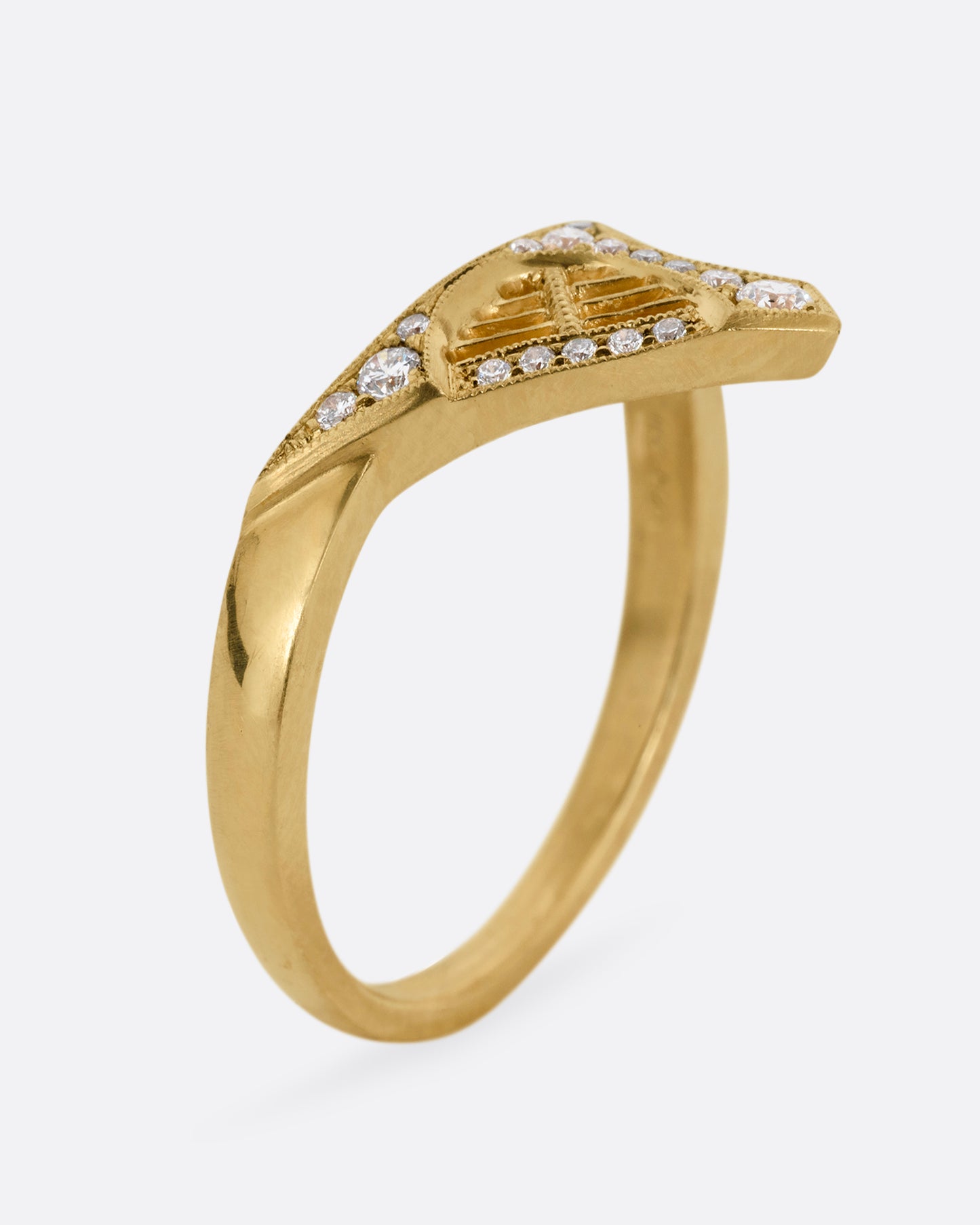 A yellow gold ring with a triangular face, white diamond accents, and cutouts. Shown standing up from the side.