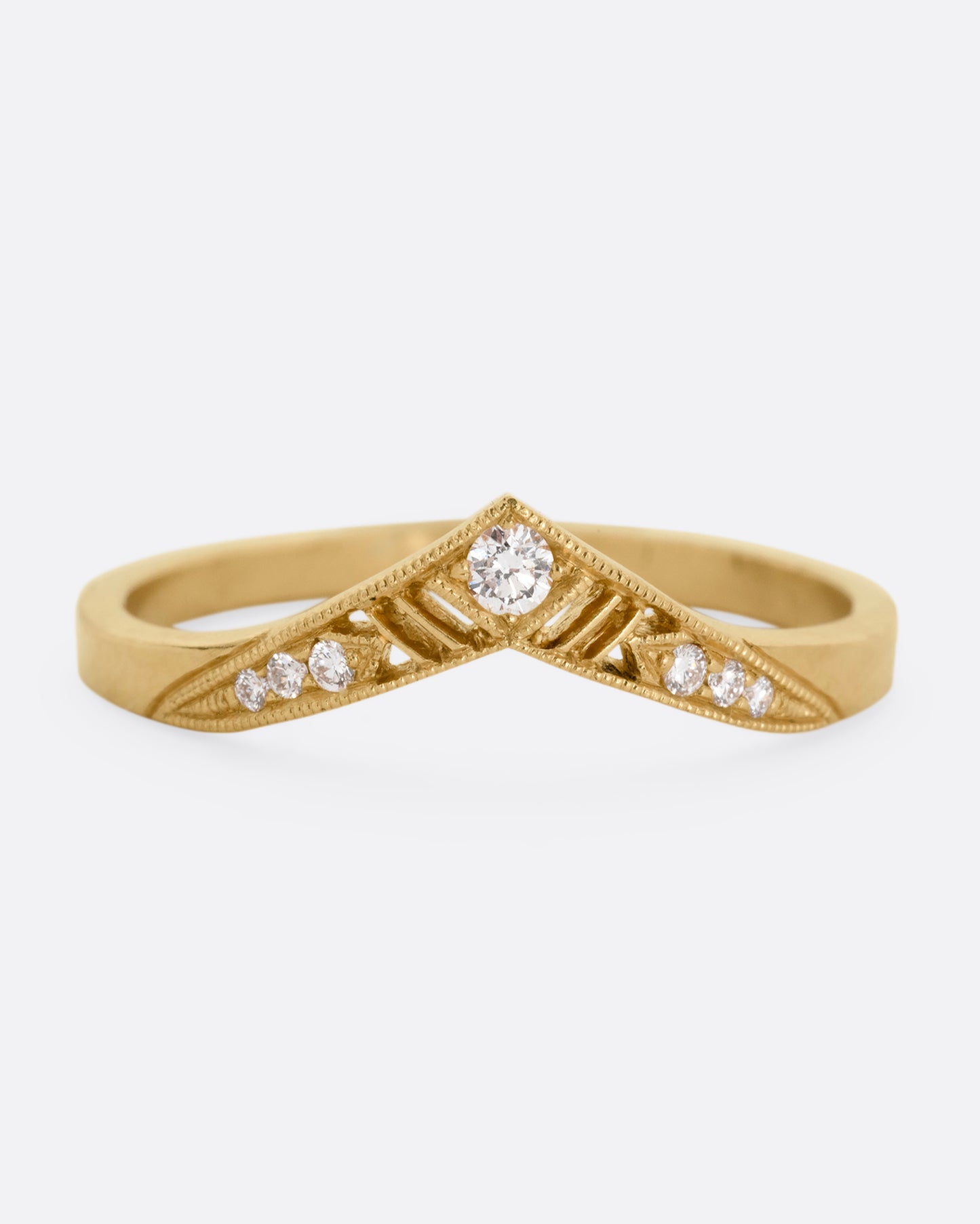 A slightly pointed yellow gold ring with diamonds and cutouts shown from the from the front.