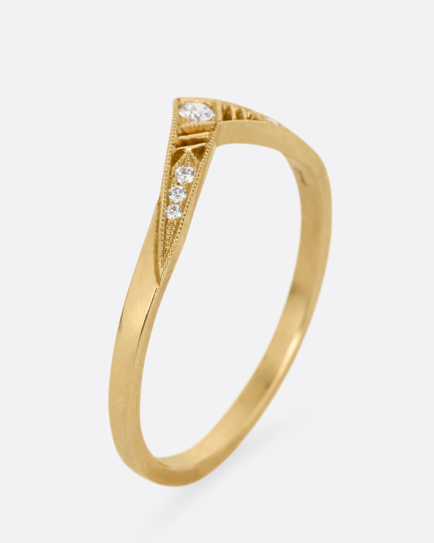 A slightly pointed yellow gold ring with diamonds and cutouts shown from the from the side standing up.