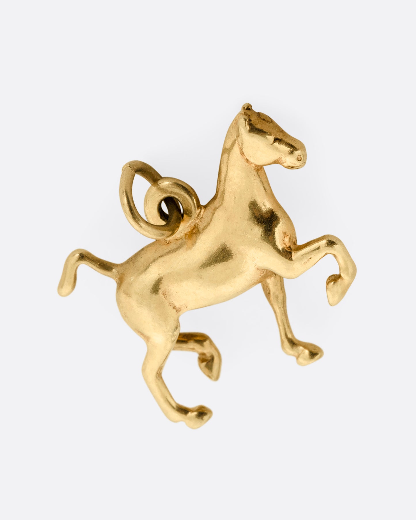 A yellow gold horse charm shown from the front.