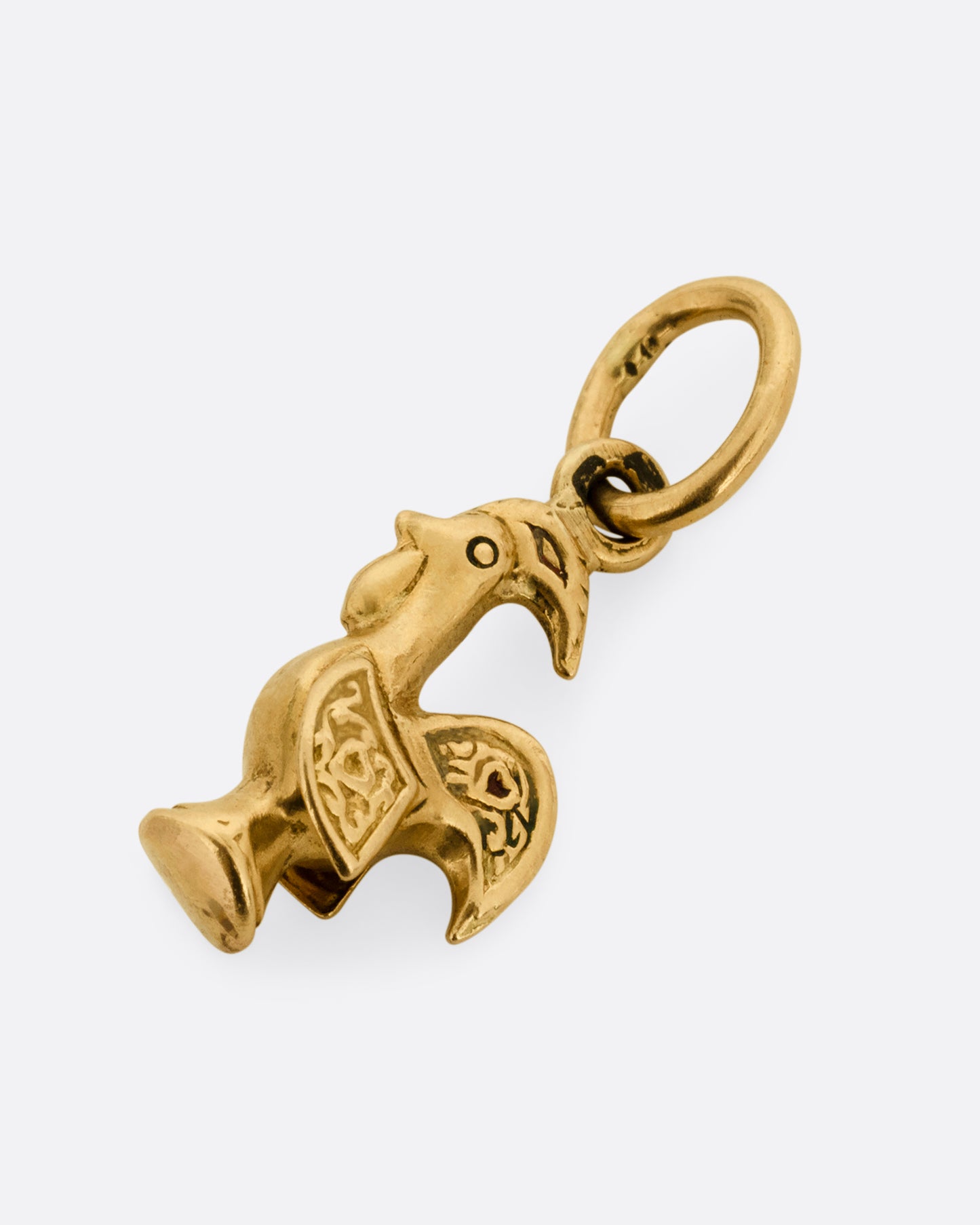 A yellow gold rooster charm shown lying flat from the front.