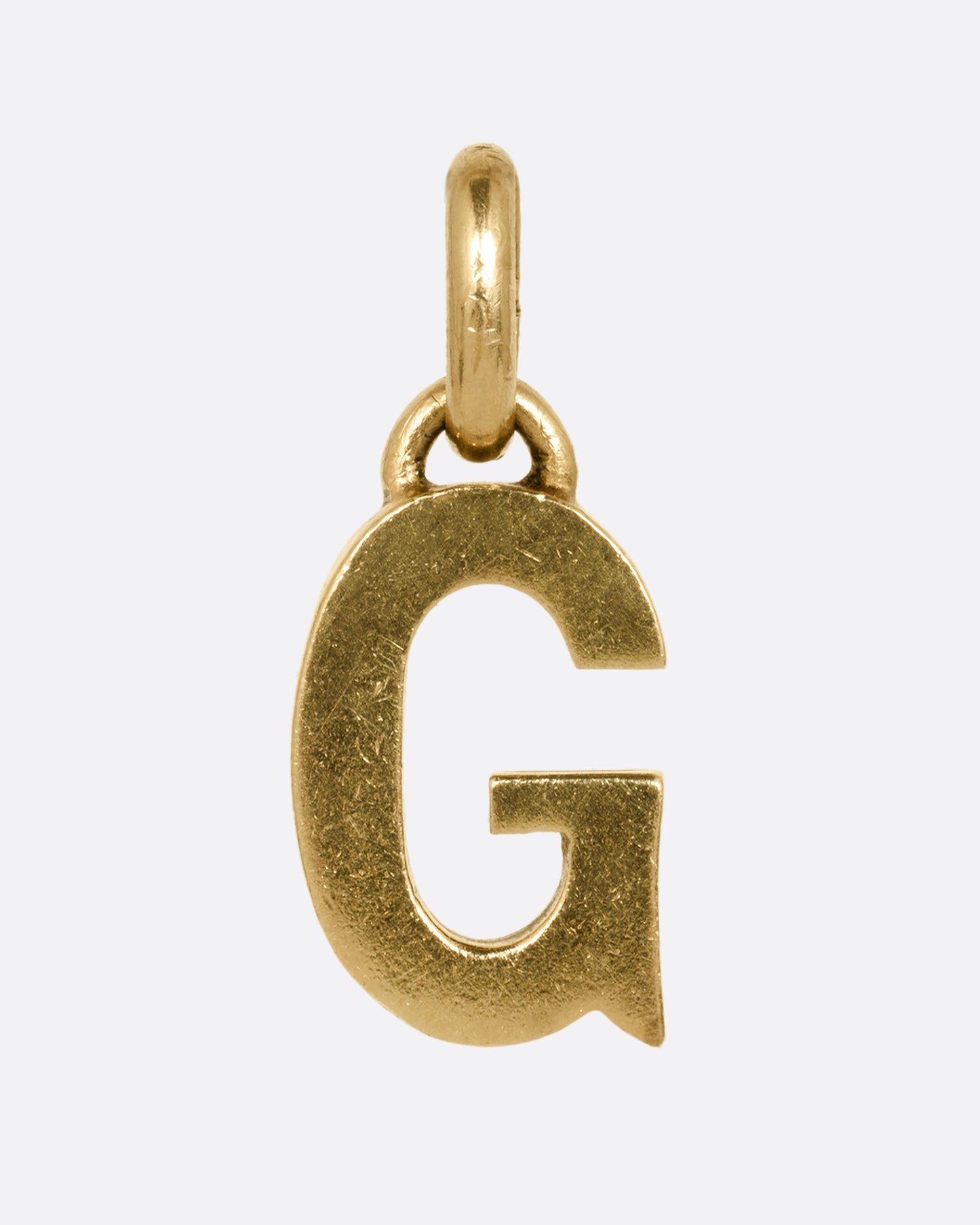 A yellow gold letter 'G' pendant shown from the front.