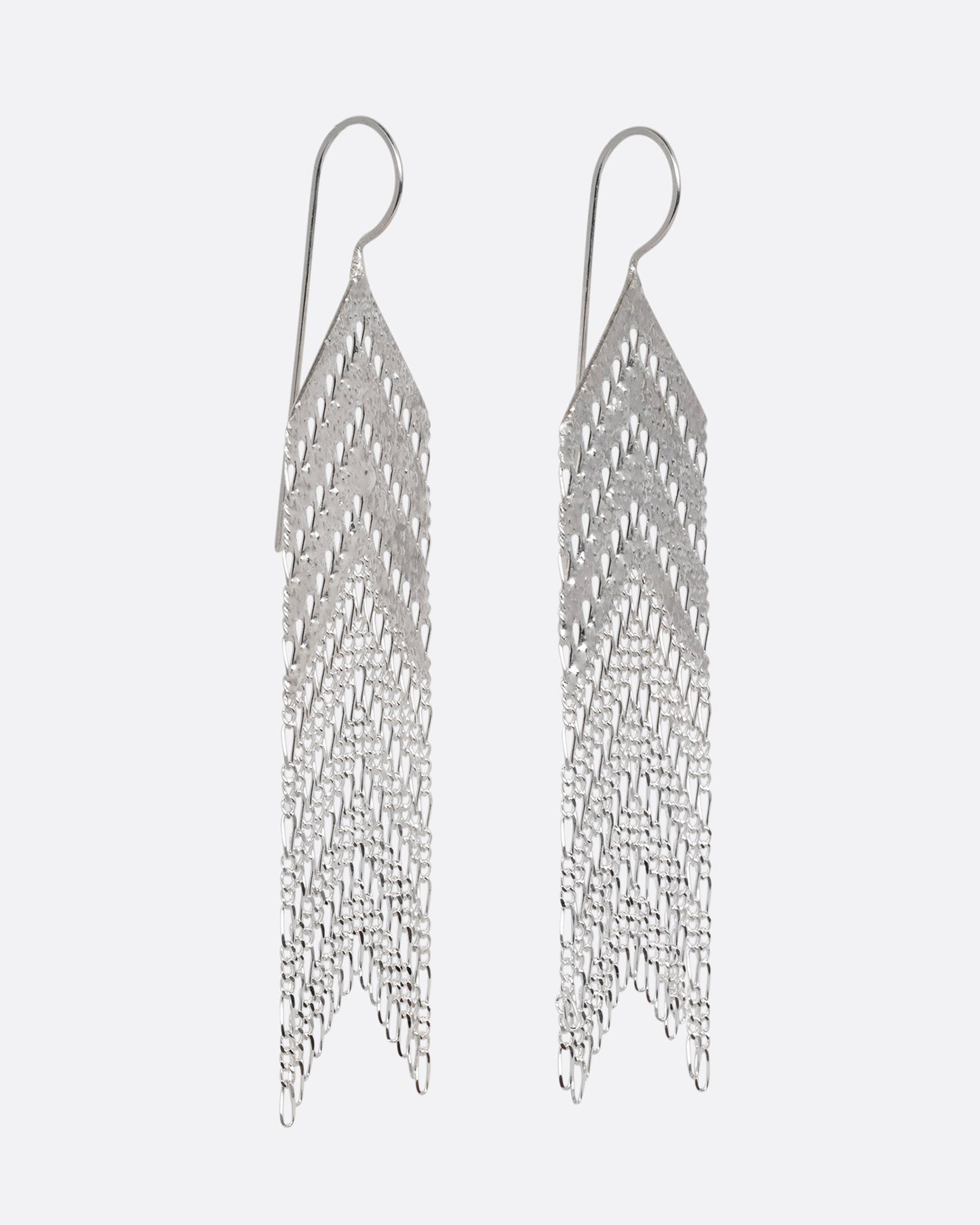 A pair of arrow shaped silver dangle earrings with Figaro chain fringe. Shown from the side.