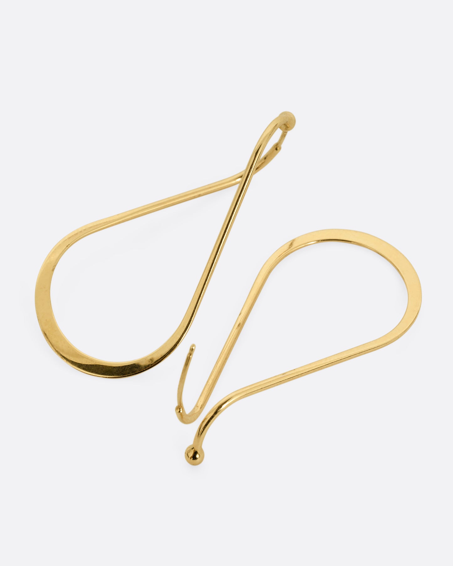 A pair of yellow gold hoop earrings with a subtle twist at the top. One earring is shown from the front, the other from the back.